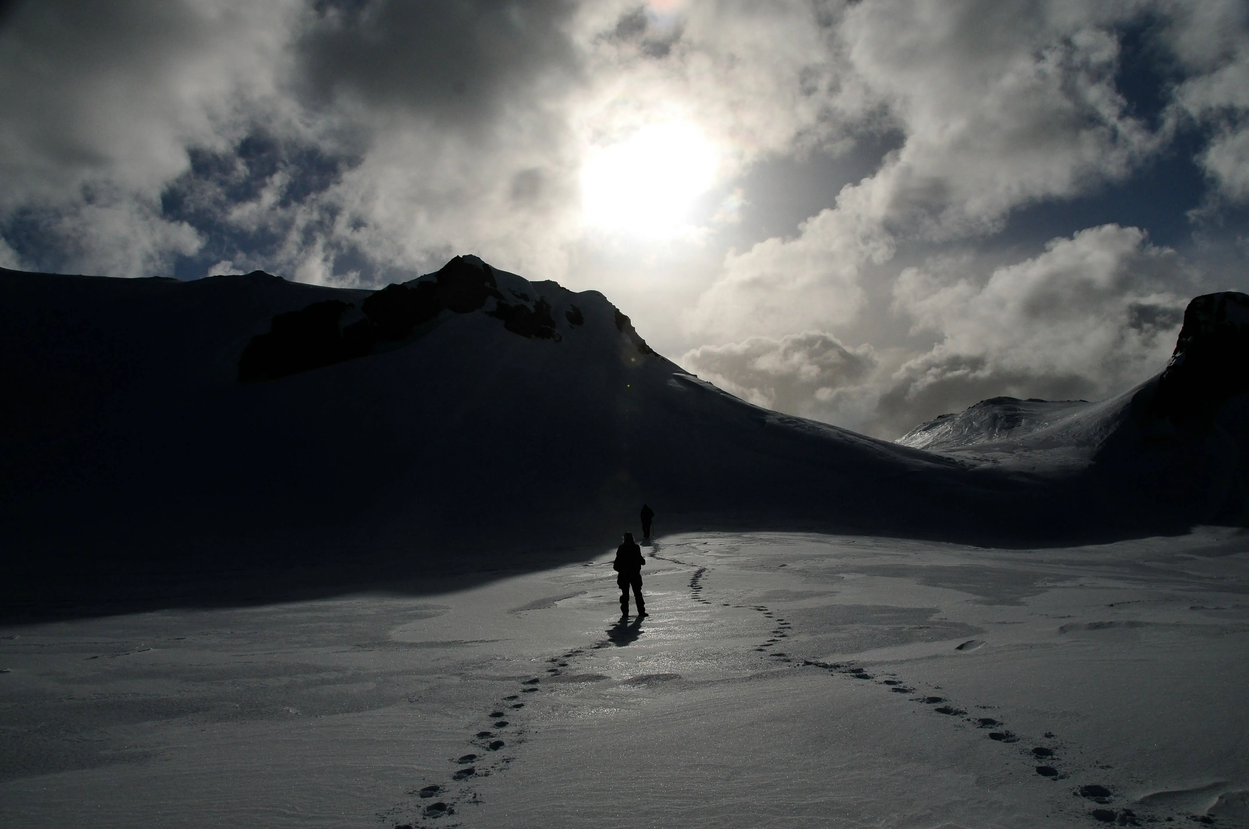 individual standing in snowy landscape before an elevation