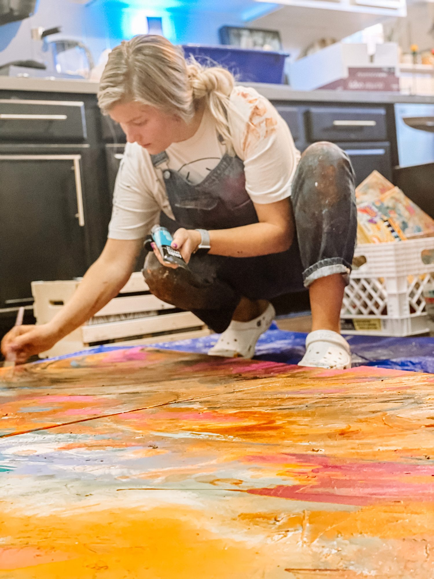 Art therapist painting on the studio floor, creative burnout recovery in Texas