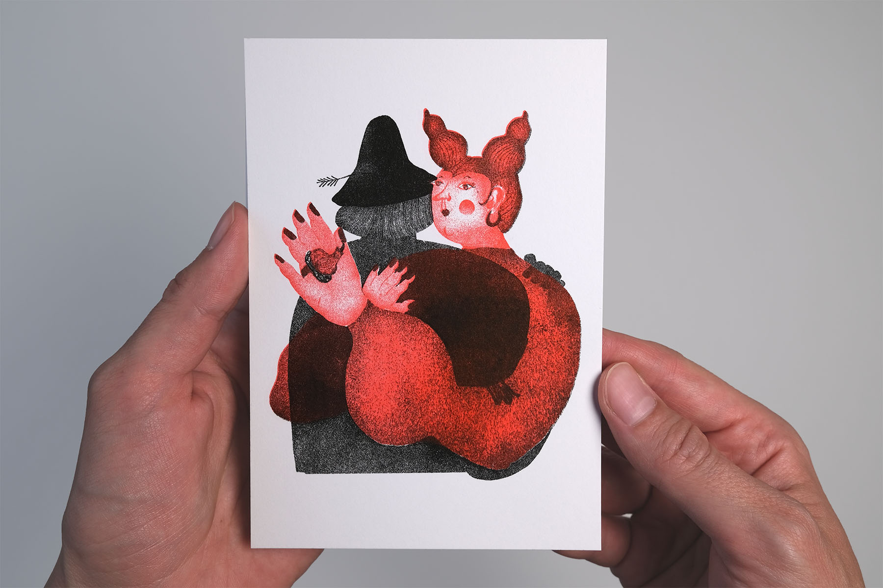 Hands holding A6 risograph print of the bride