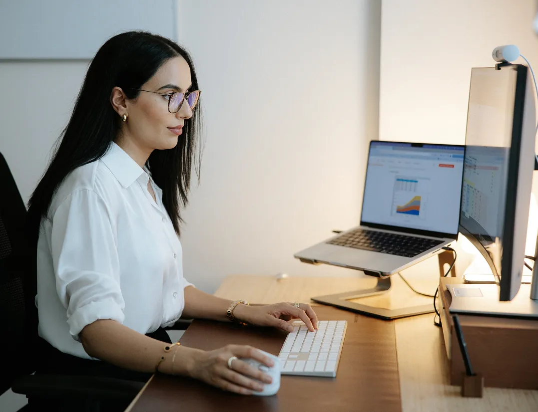 A woman sitting at a desk using a computer.