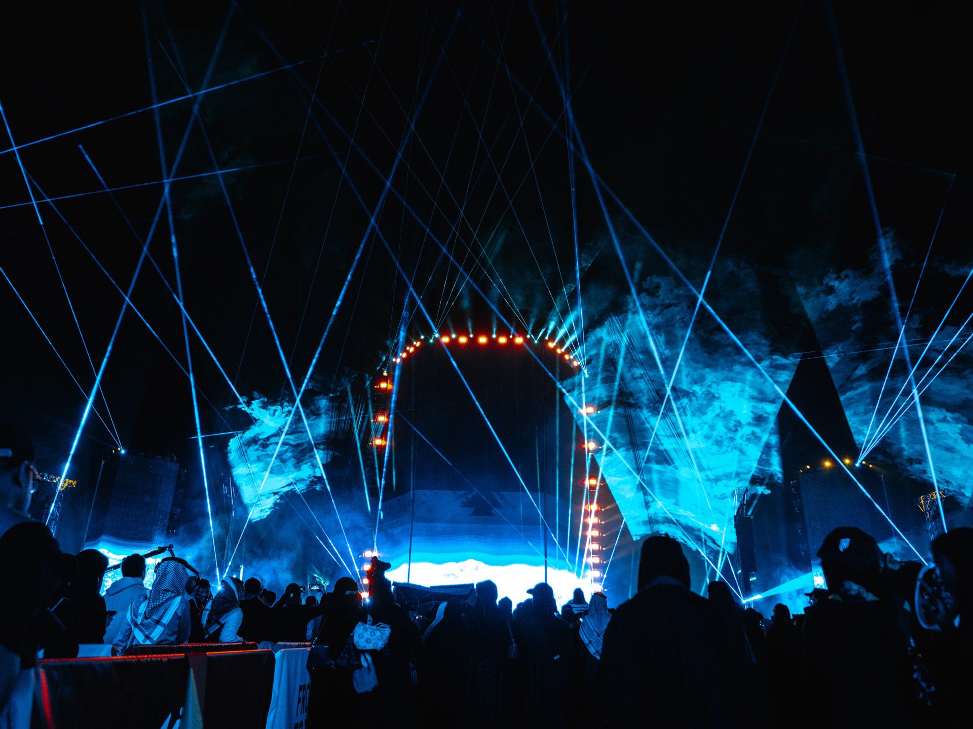 Blue laser beams and haze frame the main stage arch at Khobar Corniche during Al Qadsiah Festival 2025
