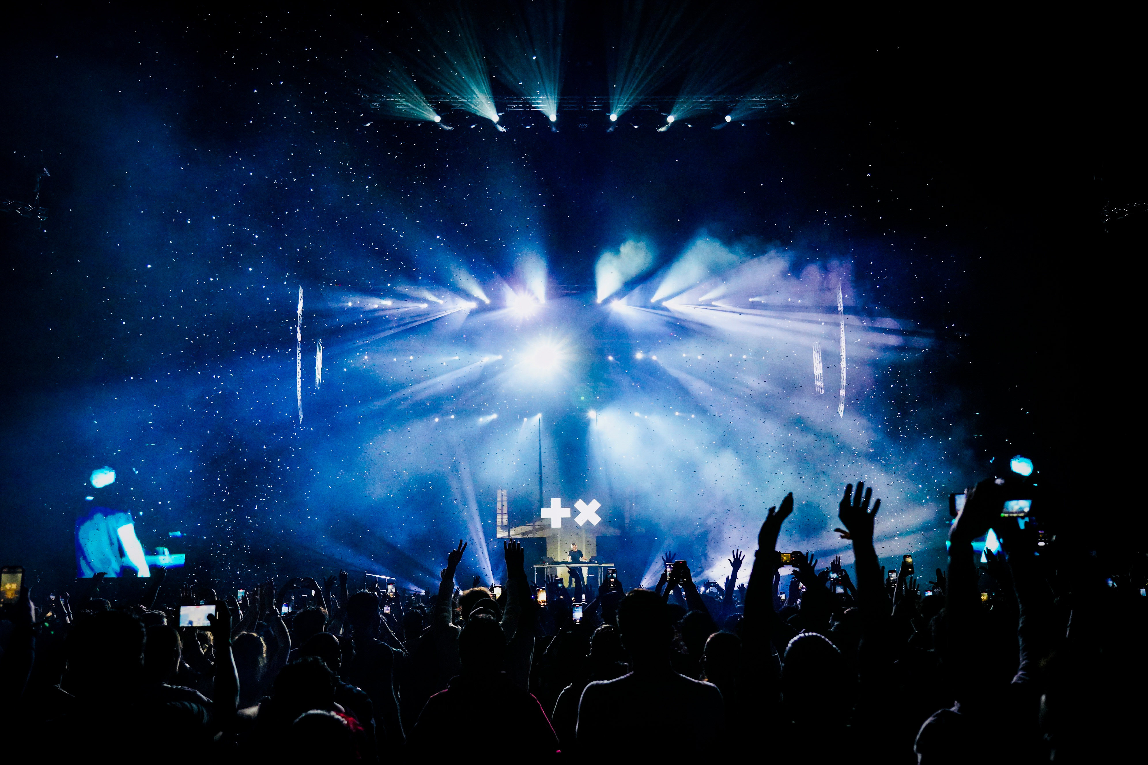 Blue beams and haze over the stage and raised hands, Martin Garrix in Dubai