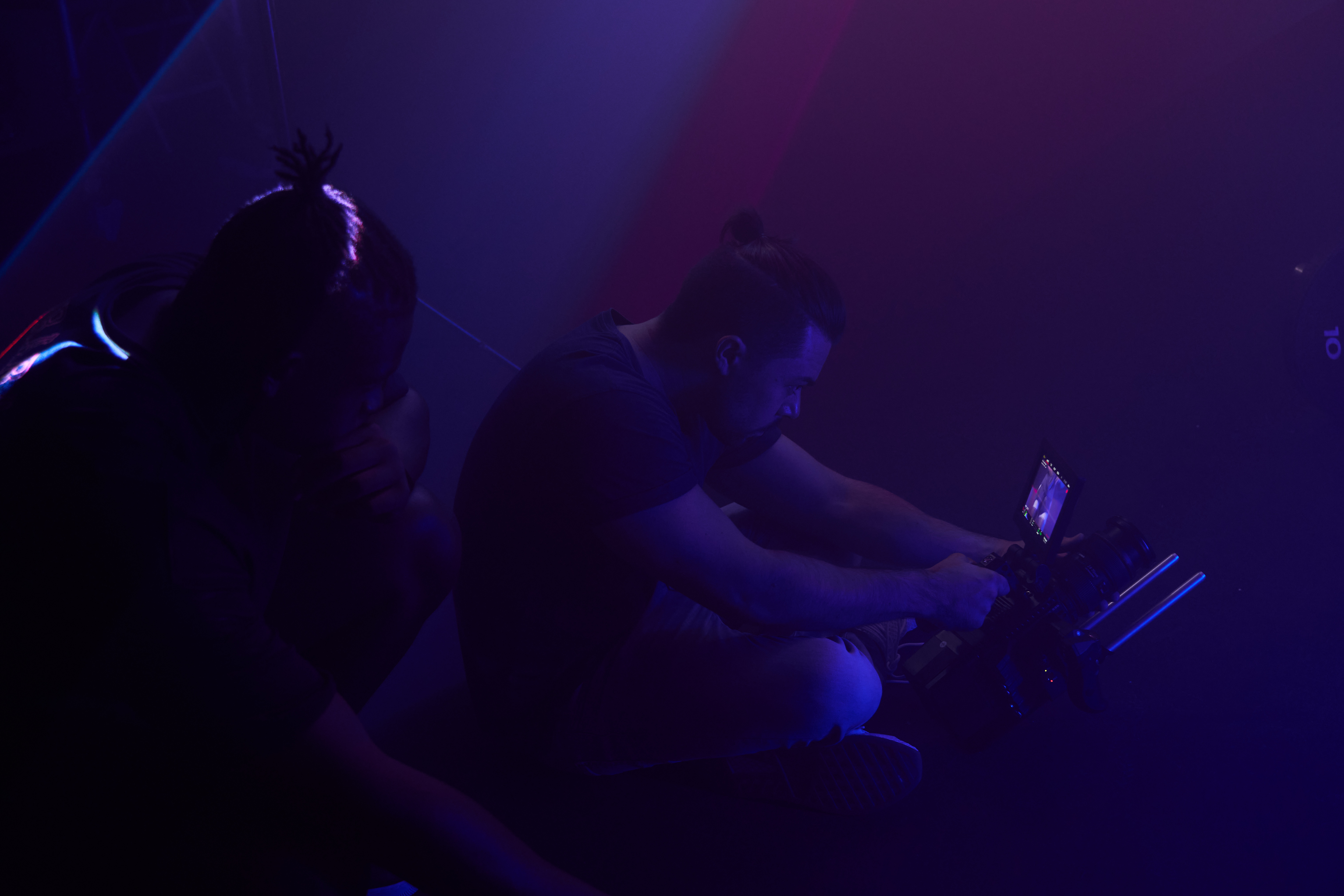 Athletes on rowers in blue haze during the shoot, Squat Wolf Commercial Video, Dubai, UAE