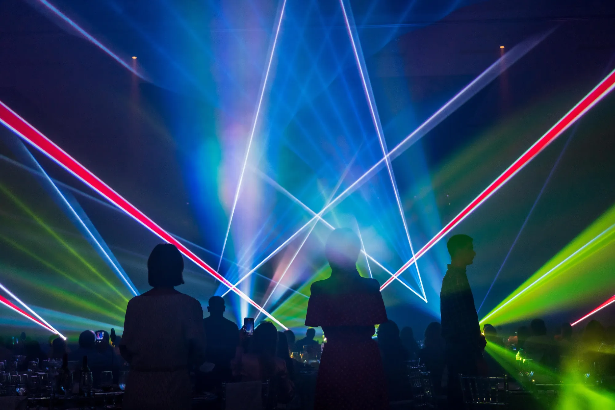 Guests silhouetted against multicolour laser beams, Cordiant Tyres Gala Dinner, Dubai, UAE