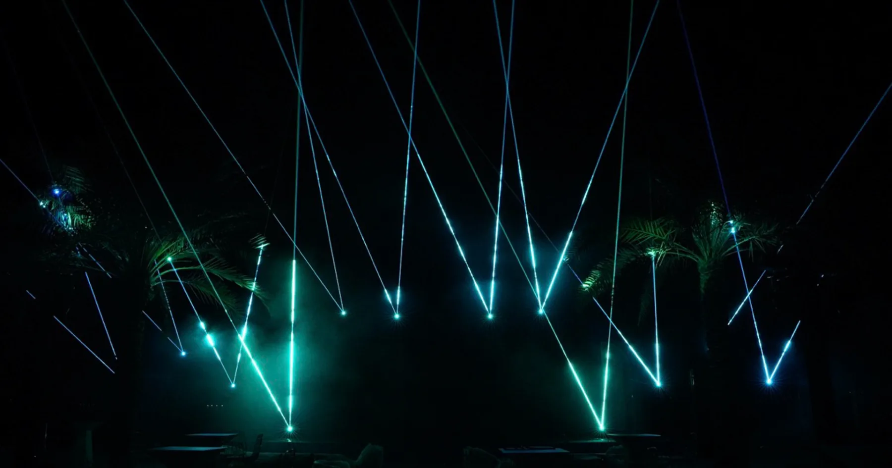 Cyan laser fans in the dark venue, ADGM 10th Anniversary, Abu Dhabi, UAE