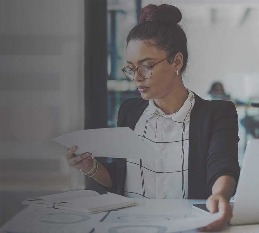 Ethnic businesswoman looking at printed documents.