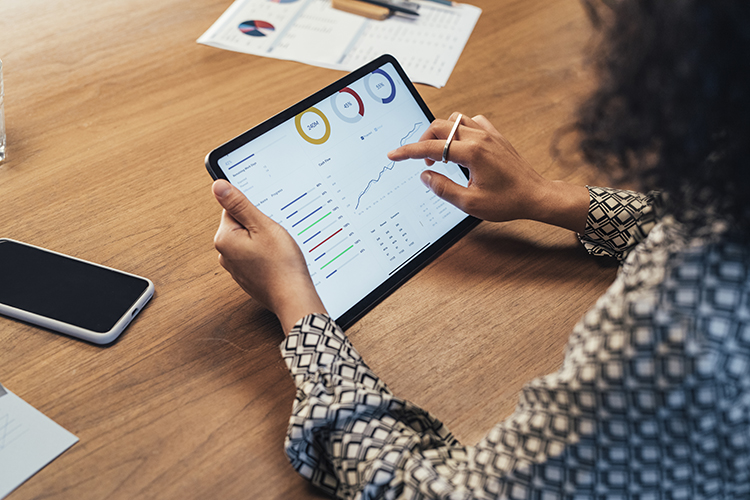 A picture featuring a businesswoman accessing graphs on a mobile tablet.
