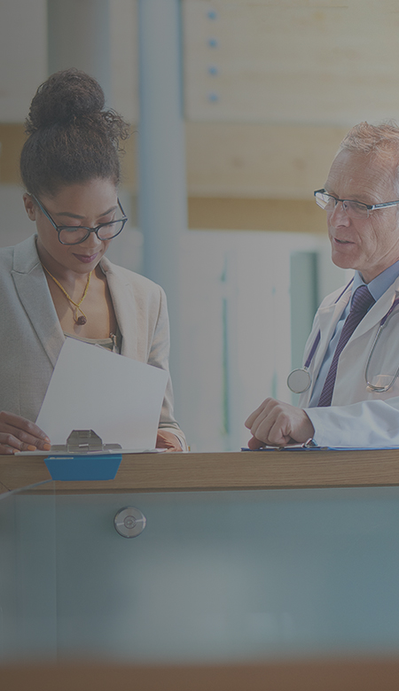 A multi-ethnic image featuring a businesswoman meeting with an elderly male physician.