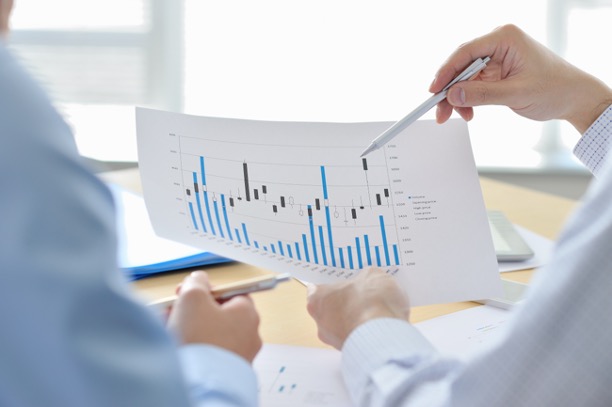 Two people looking at printout of bar graph.