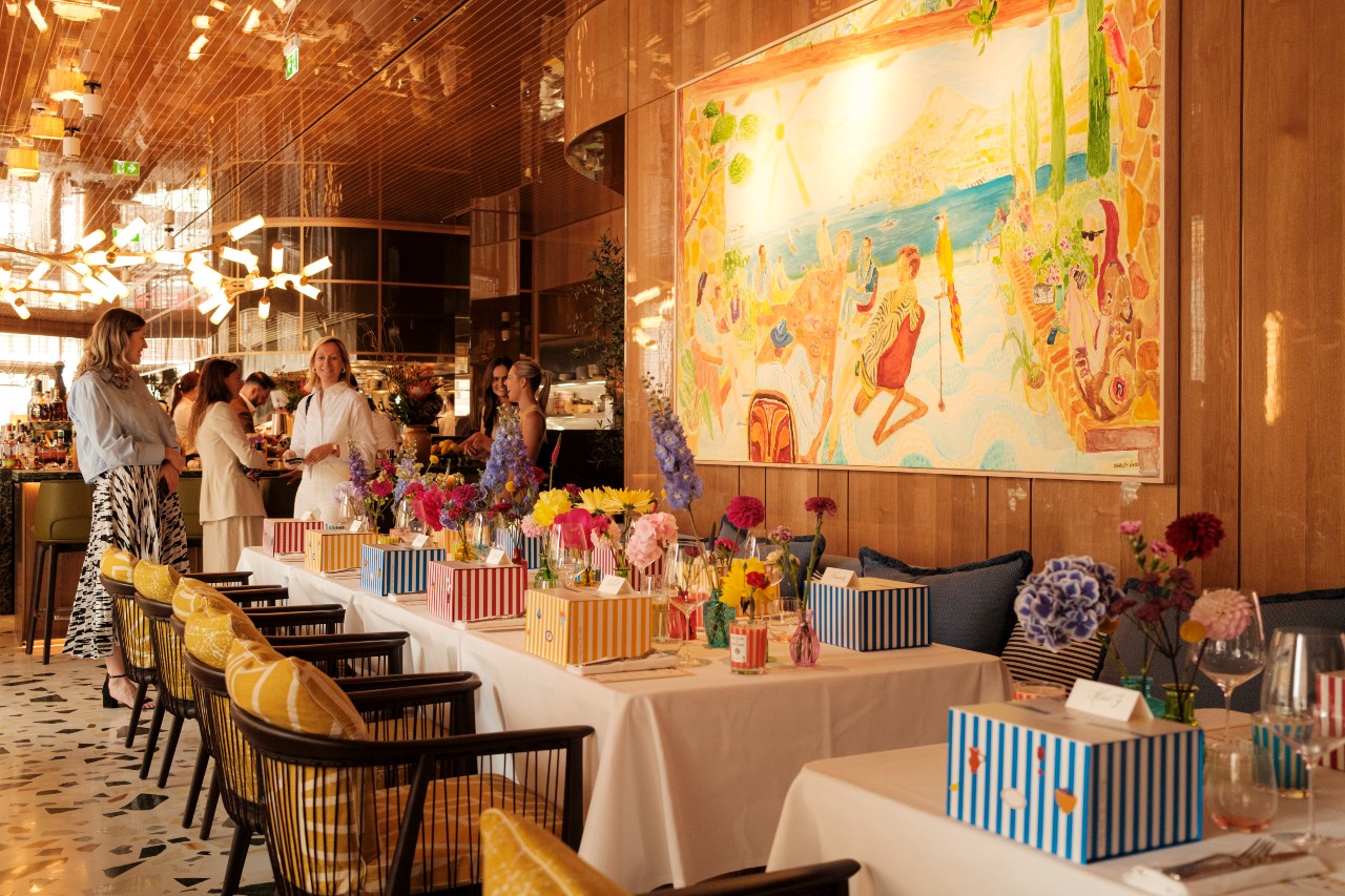 Private dining table set for a celebration at ALBA London, styled with colourful gift boxes and fresh flowers