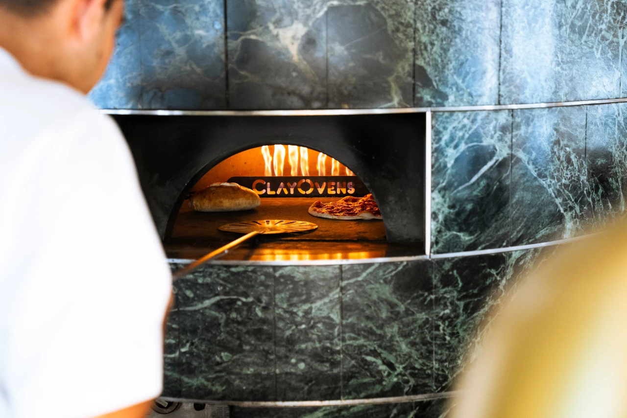 Pizza and focaccia baking in the wood-fired clay oven at ALBA London