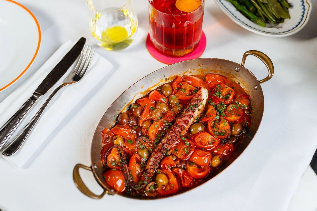 Octopus braised with cherry tomatoes, served in a copper pan at ALBA London
