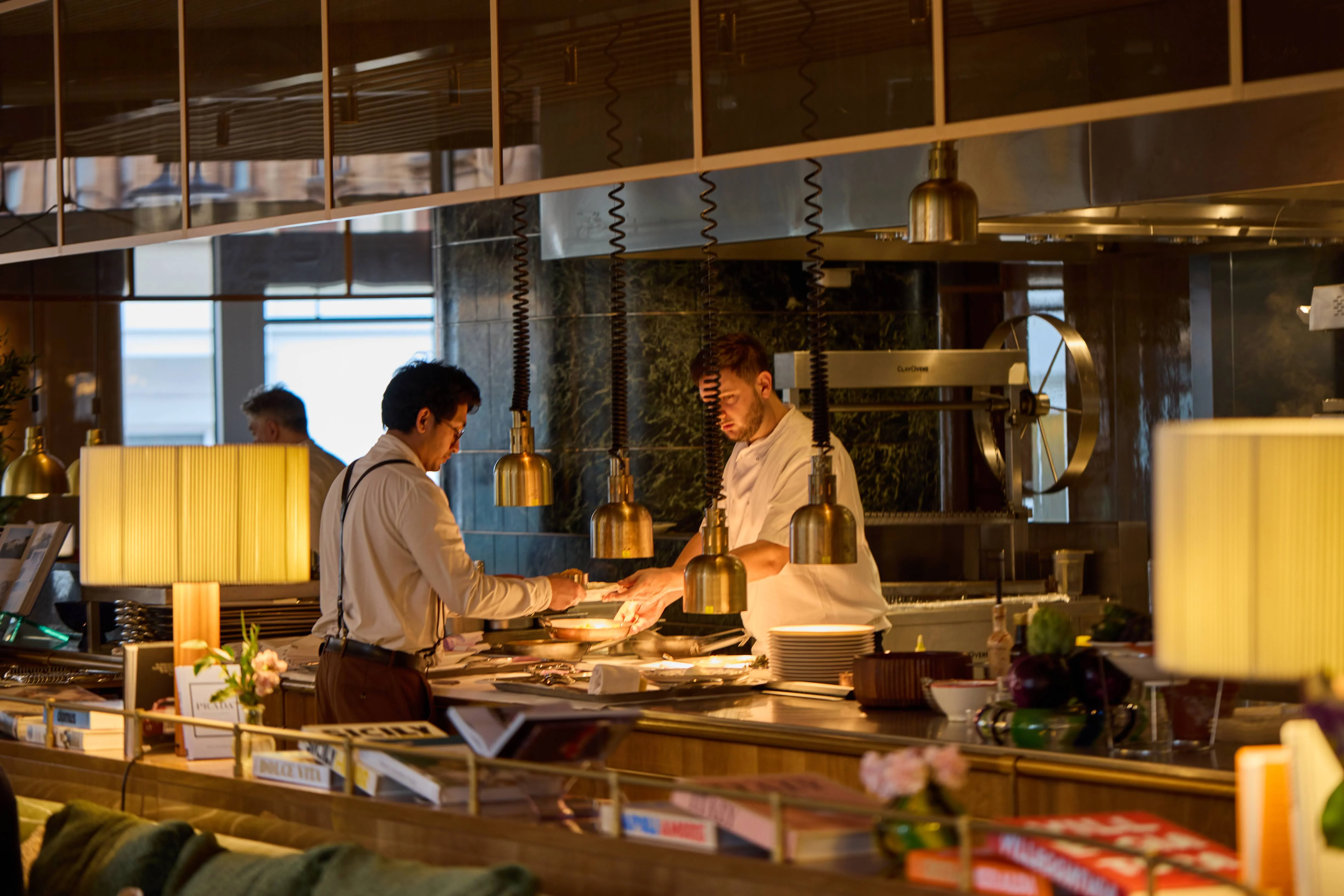 Chefs at work in Alba's open kitchen beside the wood-fired oven