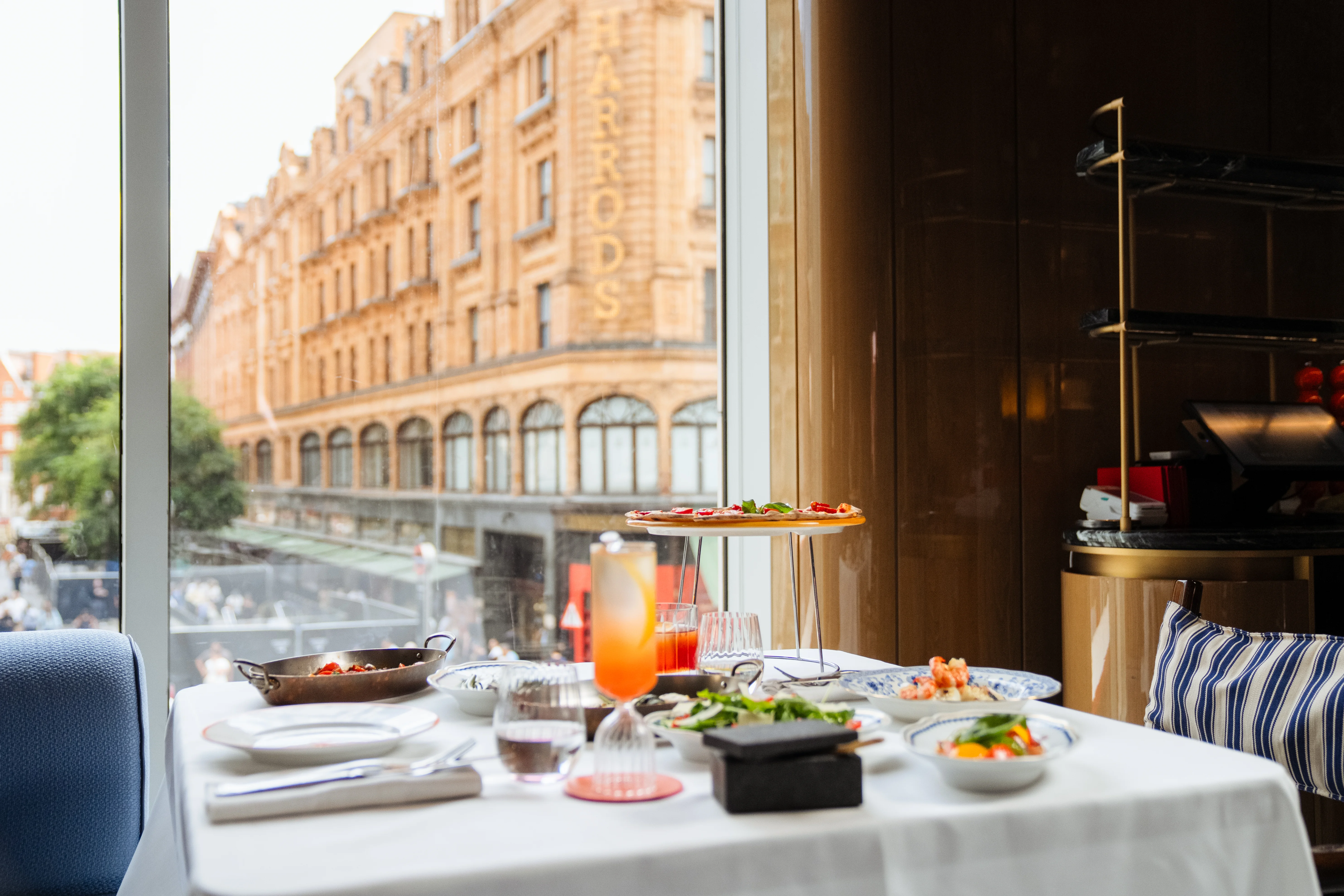 A lunch table at ALBA London's window, looking across Brompton Road to Harrods