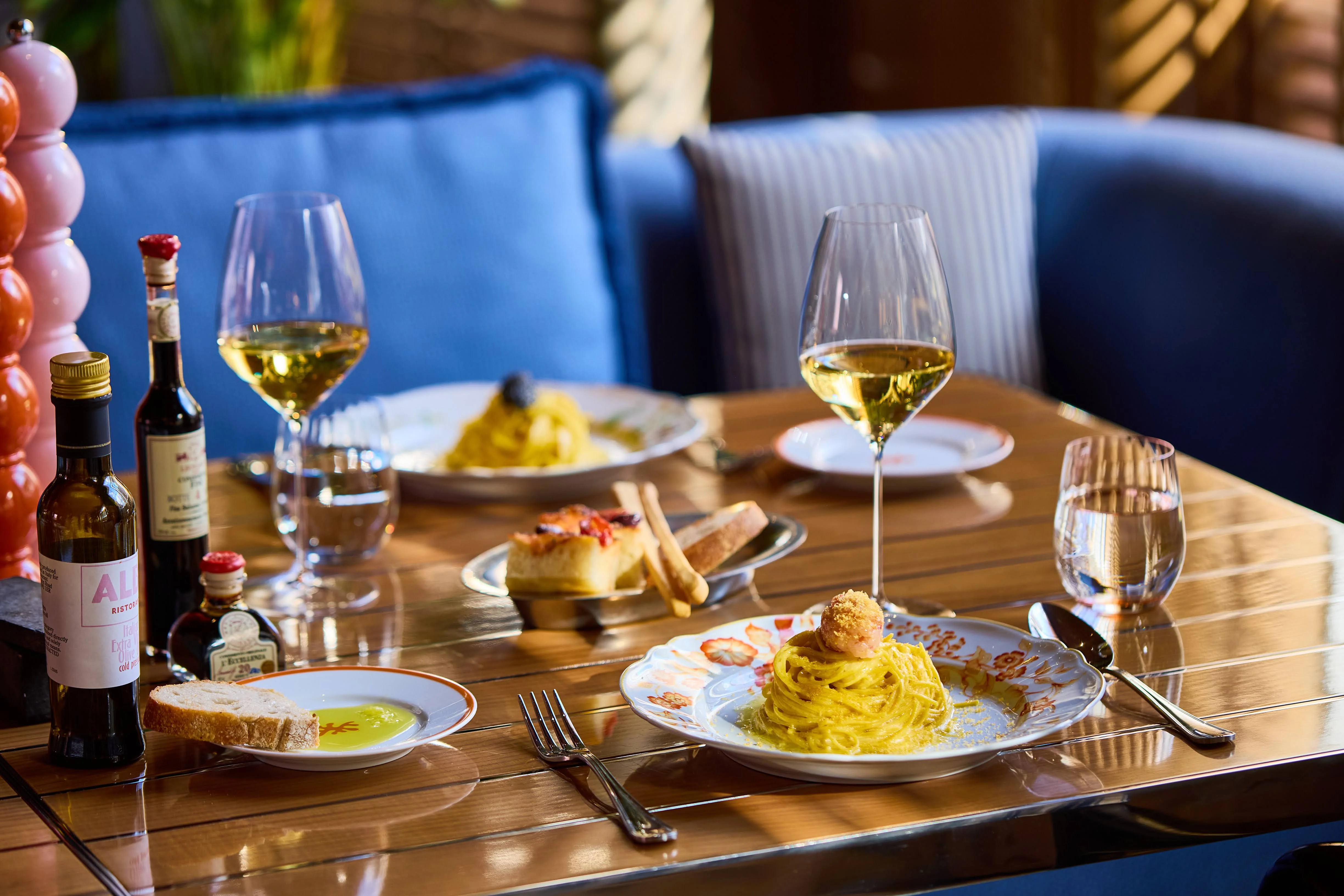 Pasta dishes and white wine on a table at ALBA London