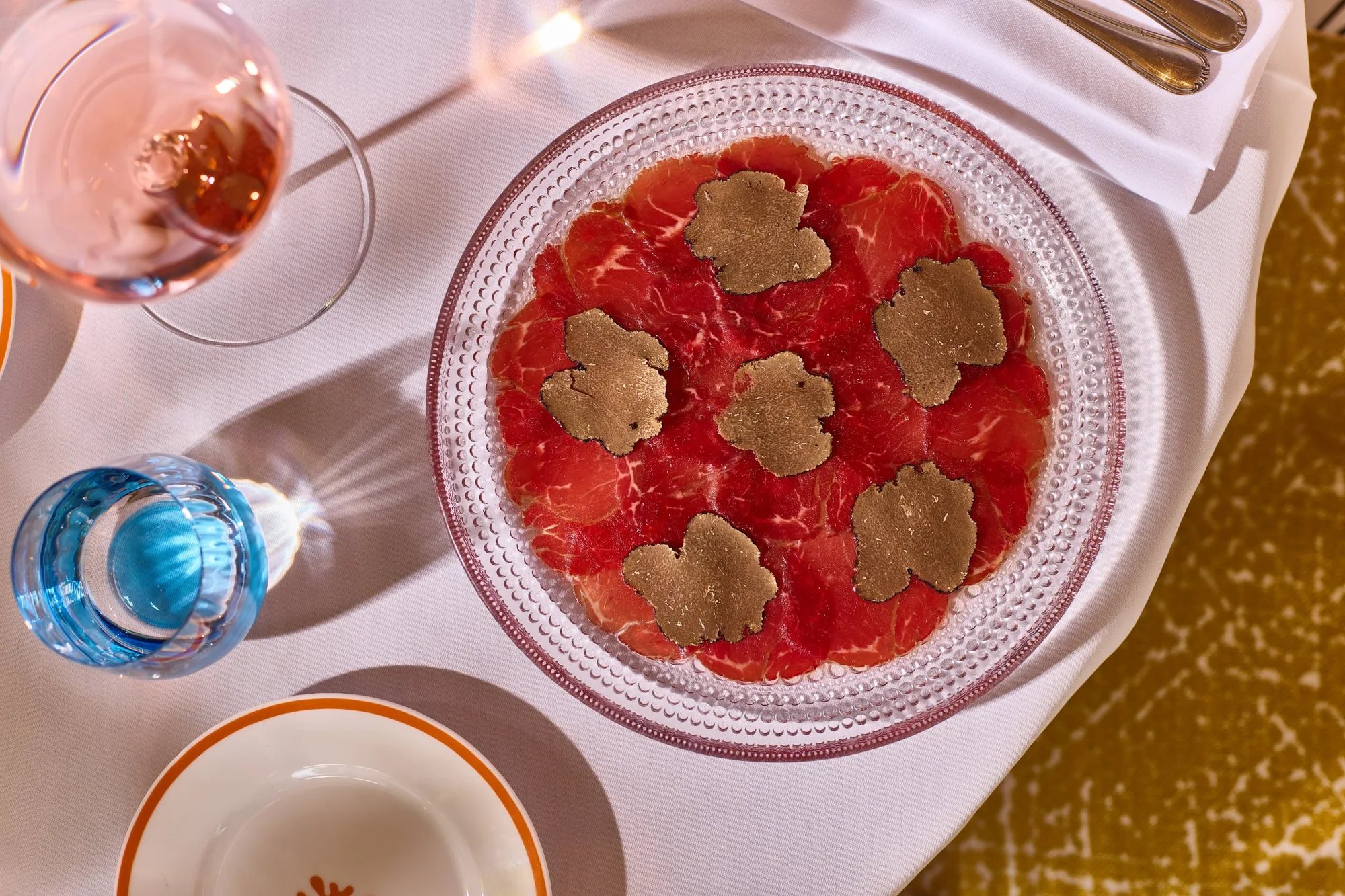 Beef carpaccio with shaved black truffle on a glass plate at ALBA, Italian restaurant, Knightsbridge