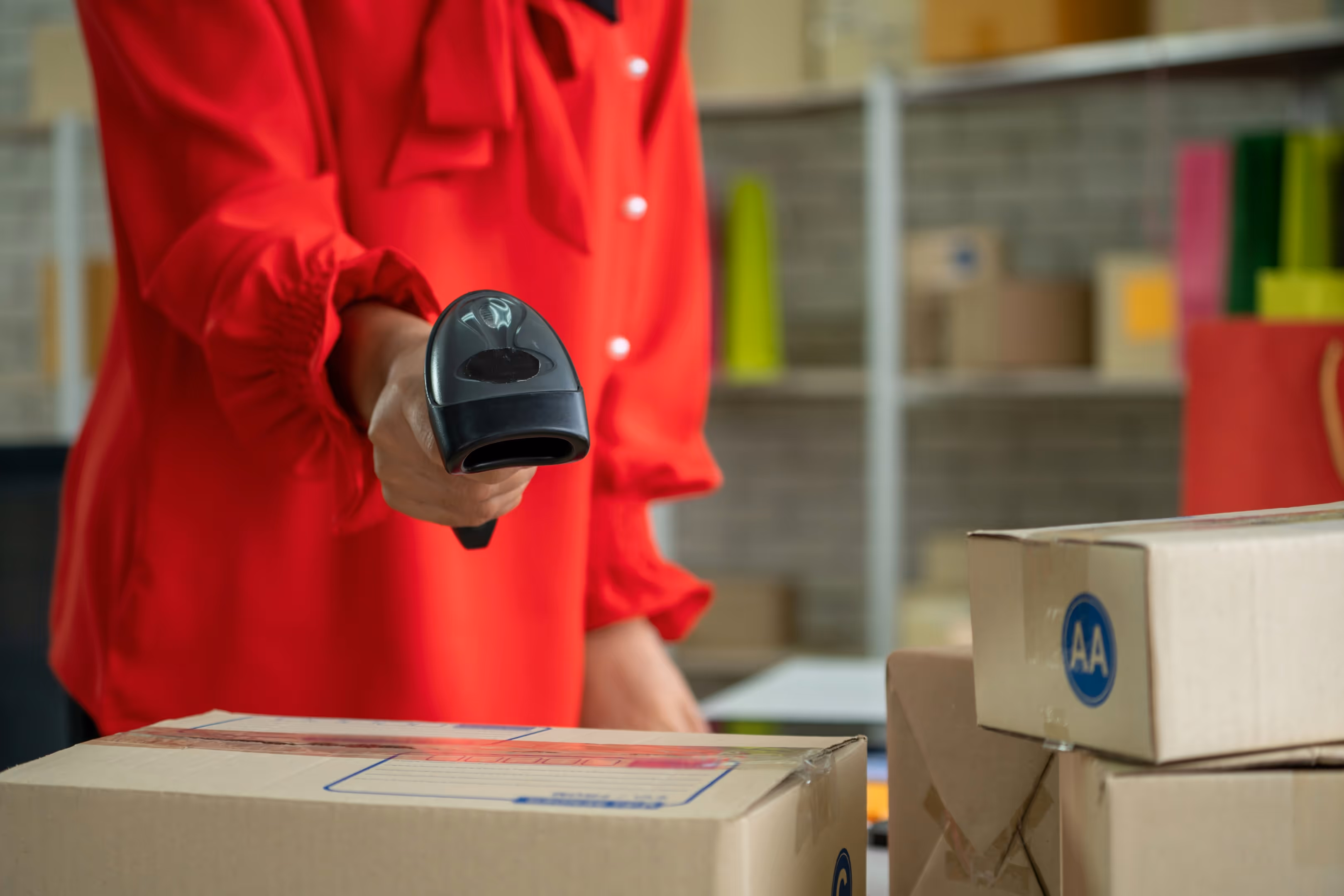 A woman in a red shirt scanning a package