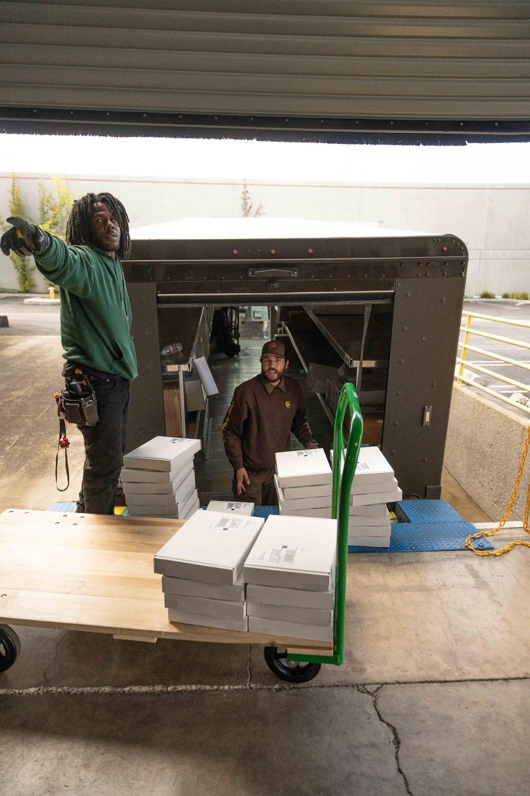 A UPS truck being unloaded at a warehouse loading dock