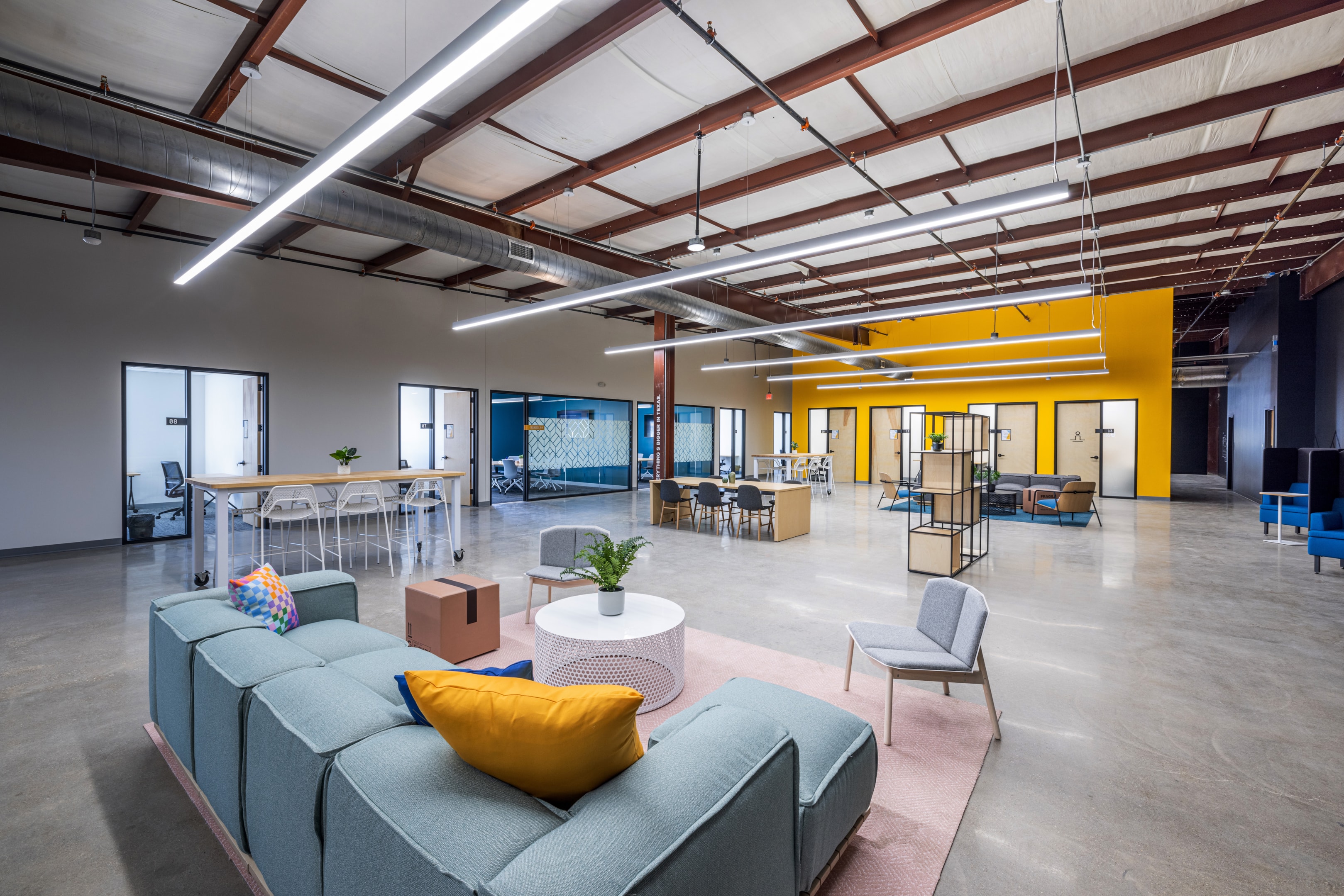 A bright and organized co-warehousing facility full of couches, tables, and more for small businesses to access.