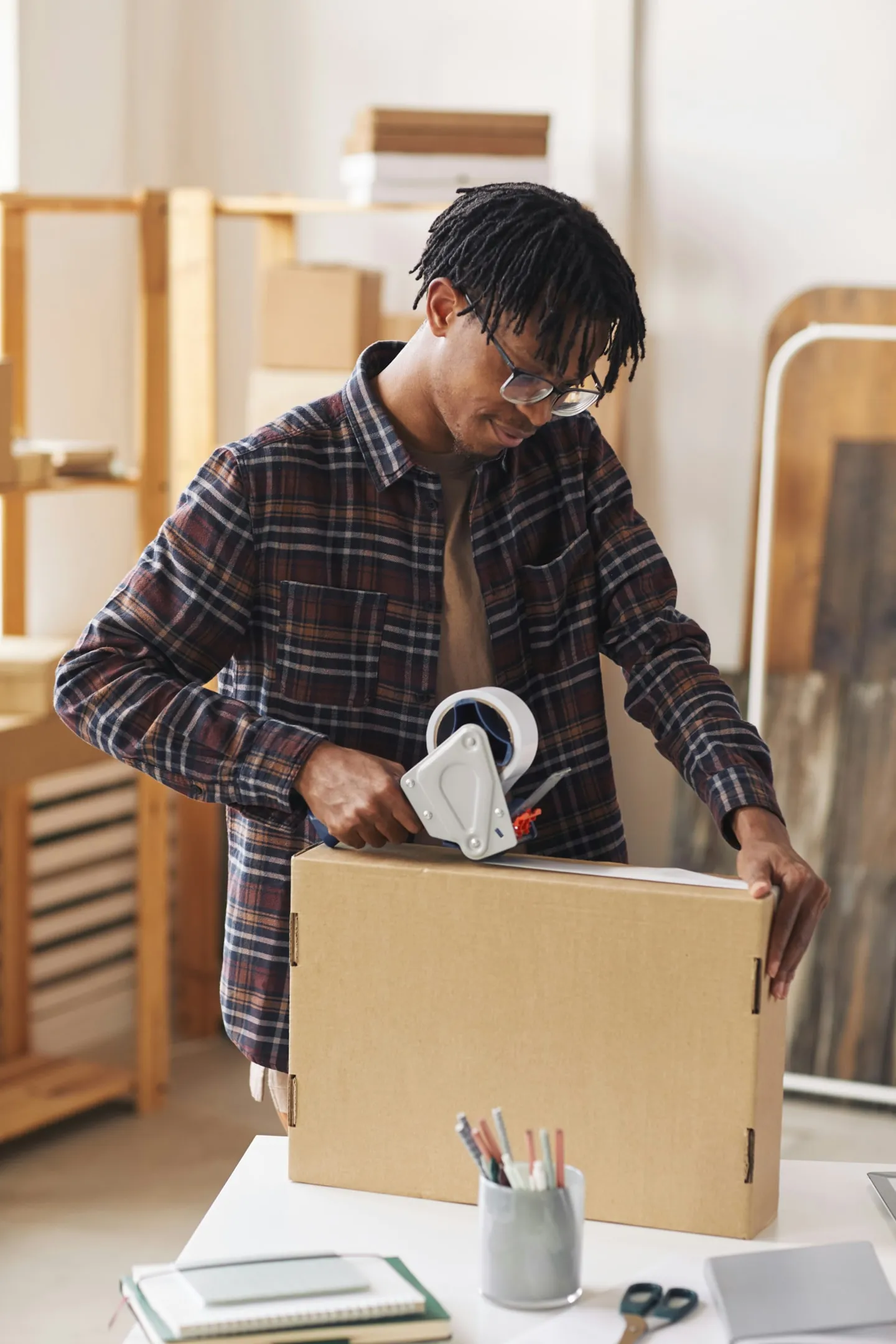 A small business owner taping a customer order to be shipped out.