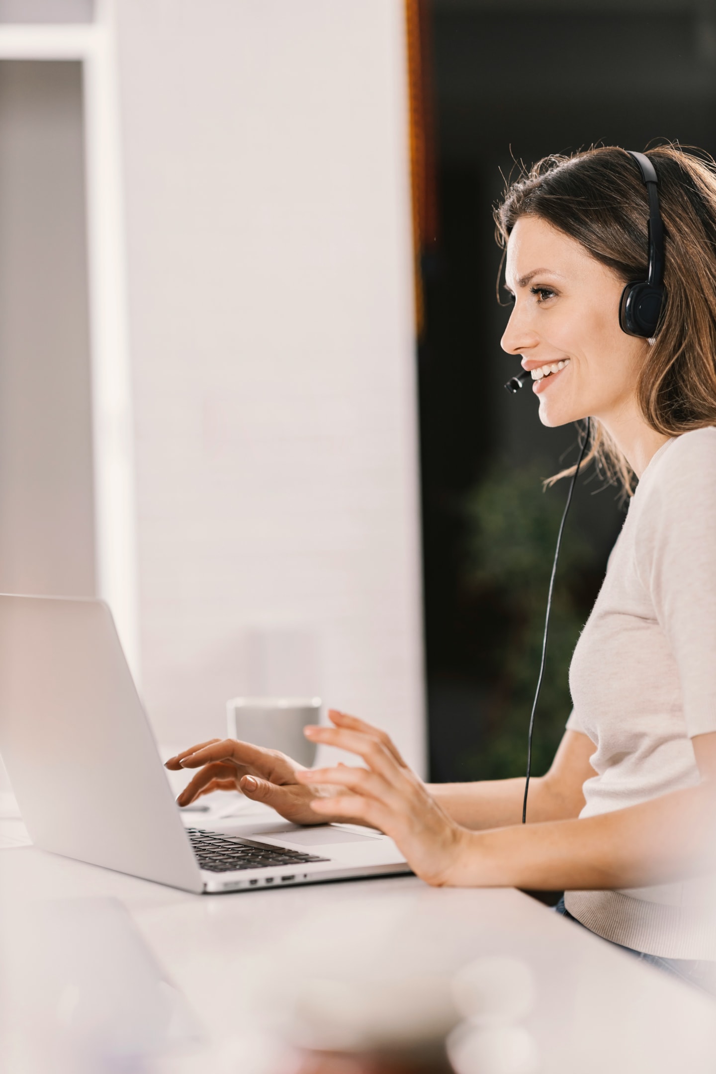 Person working on a laptop with a customer service headset representing online support and communication systems.