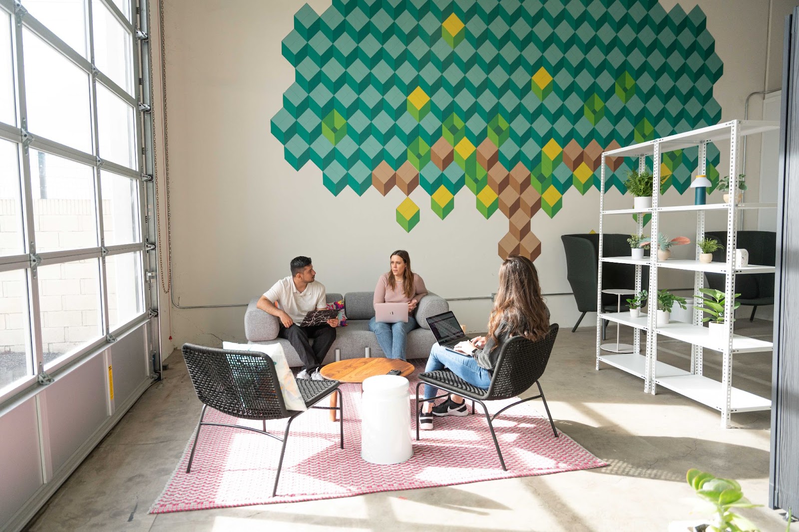 Small business employees sitting arund a table at Saltbox chatting with the on-site team about their scaling strategy.