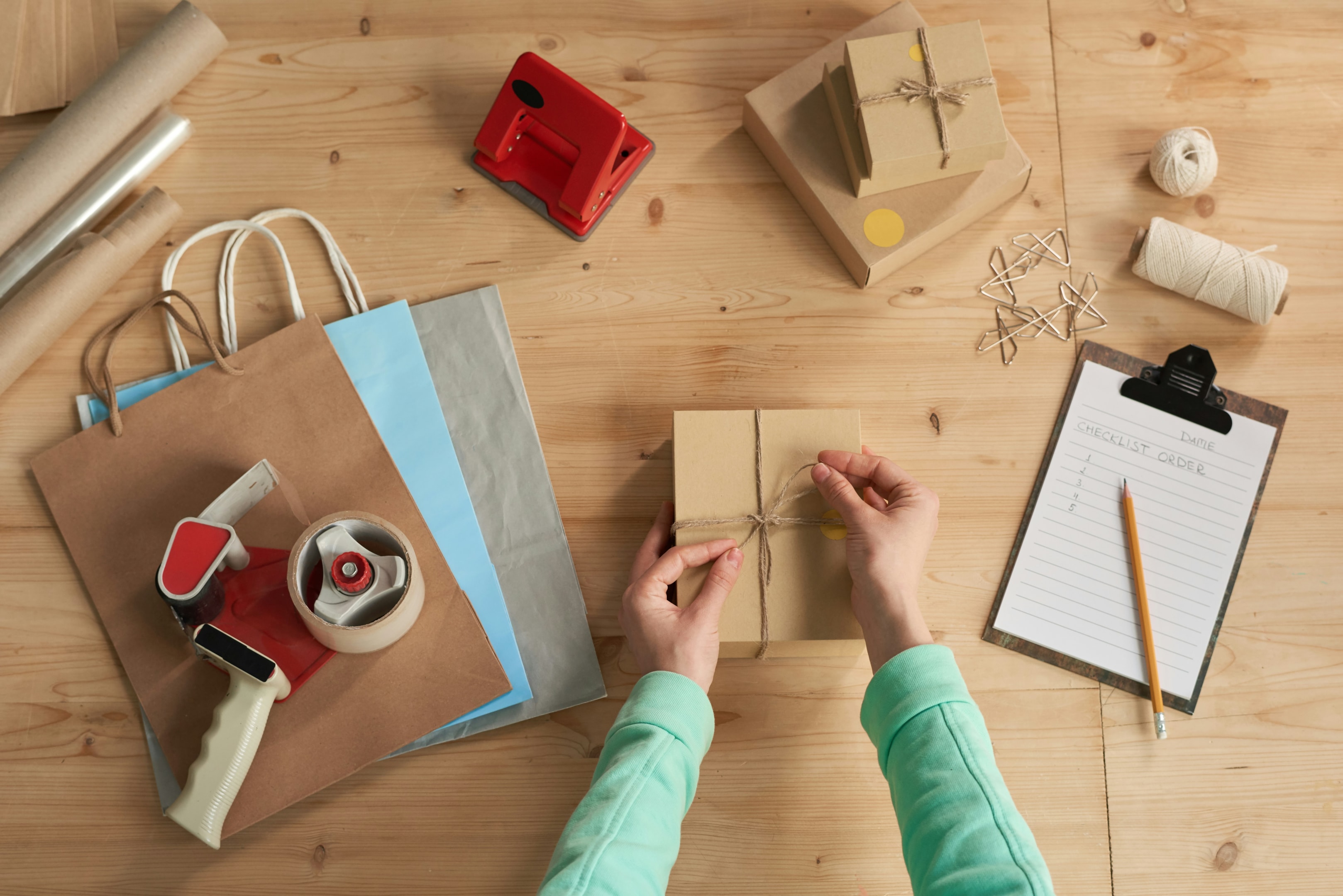 An online store owner packing a holiday shipment and building a Black Friday strategy to attract customers and create a seamless shopping experience.
