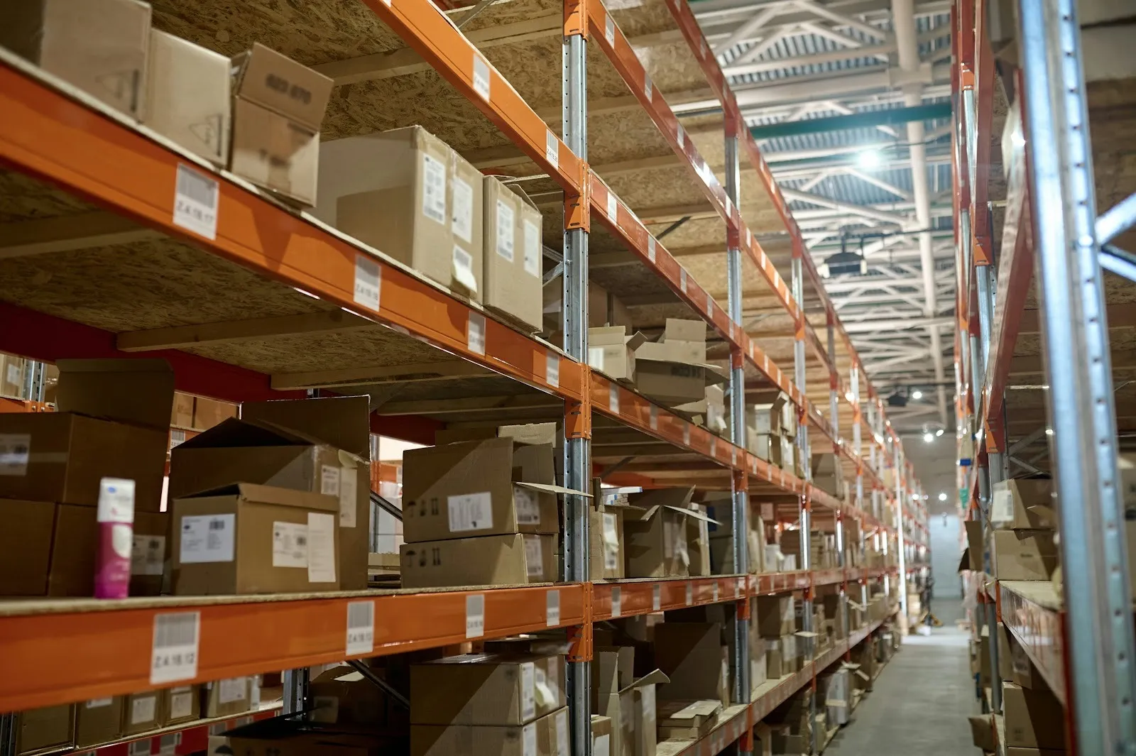 The image depicts a warehouse shelving unit filled with neatly organized and labeled product boxes, all prepared for shipment, showcasing efficient fulfillment center operations essential for Amazon sellers. The orderly arrangement highlights the importance of proper prep and labeling services in the shipping process for successful fulfillment by Amazon.