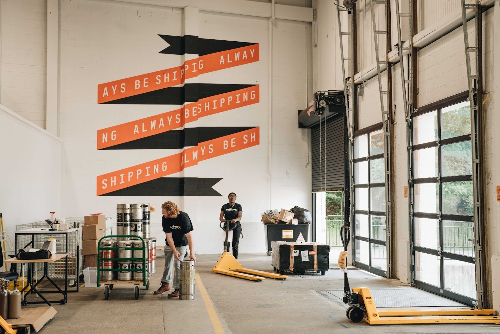 Two saltbox employees help members unload product in their co-warehousing suite.