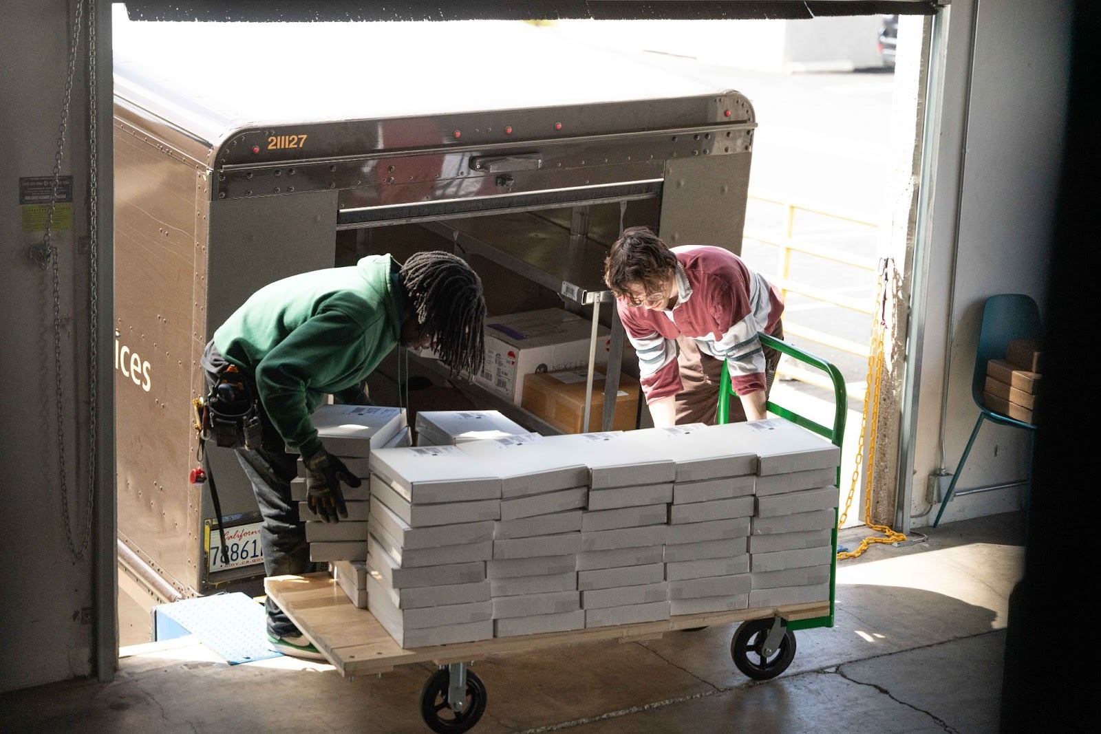 Two Saltbox team members support a member's holiday shipping strategy by loading inventory into a truck.