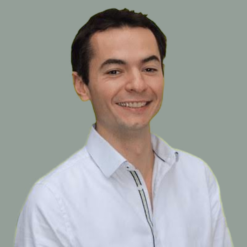 Emmnuel ALQIUIER, fondateur de Fodmapedia, souriant portant une chemise blanche sur fond vert vif.