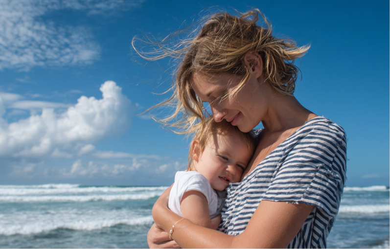 Mutter und Kind während der Kur am Strand Mutter und Kind in der Sonne am Strand