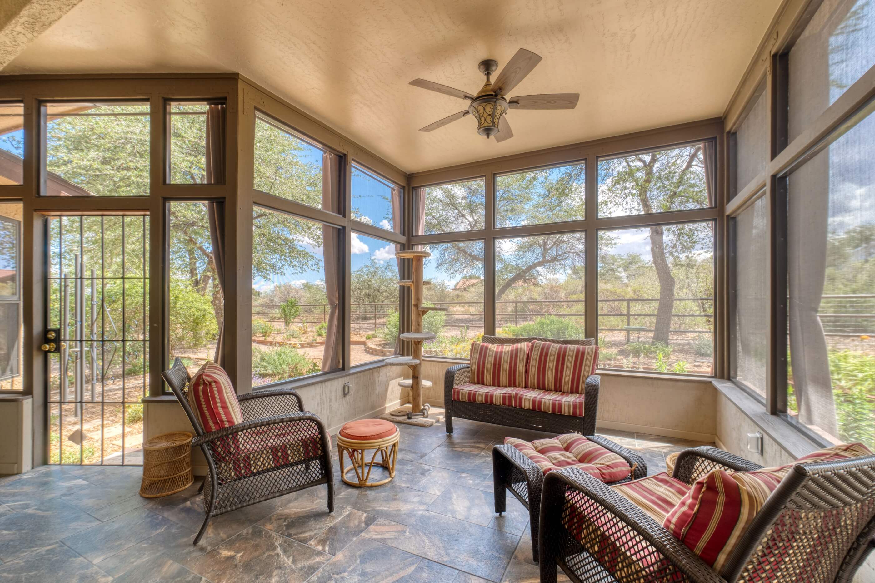 Sunroom with wicker furniture and garden views