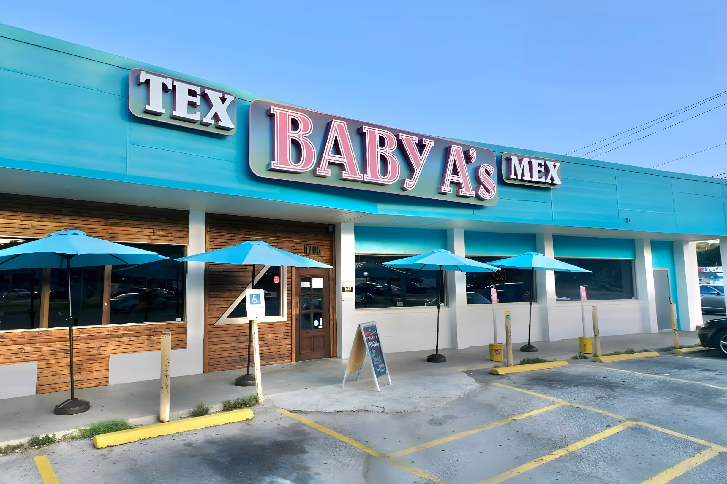 Exterior of Baby A's Tex Mex restaurant with turquoise awnings and ample parking space.