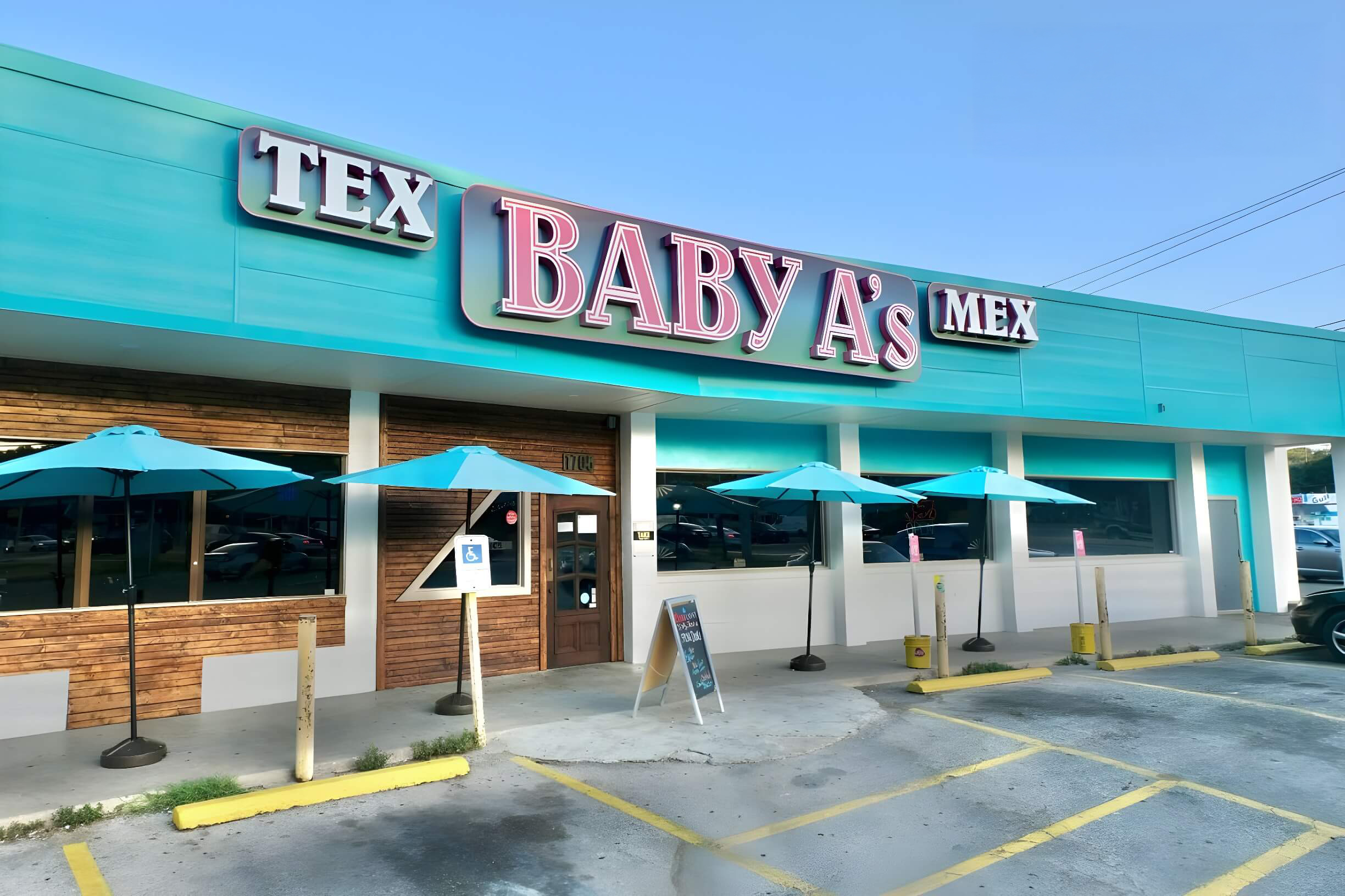 Exterior of Baby A's Tex Mex restaurant with turquoise awnings and ample parking space.