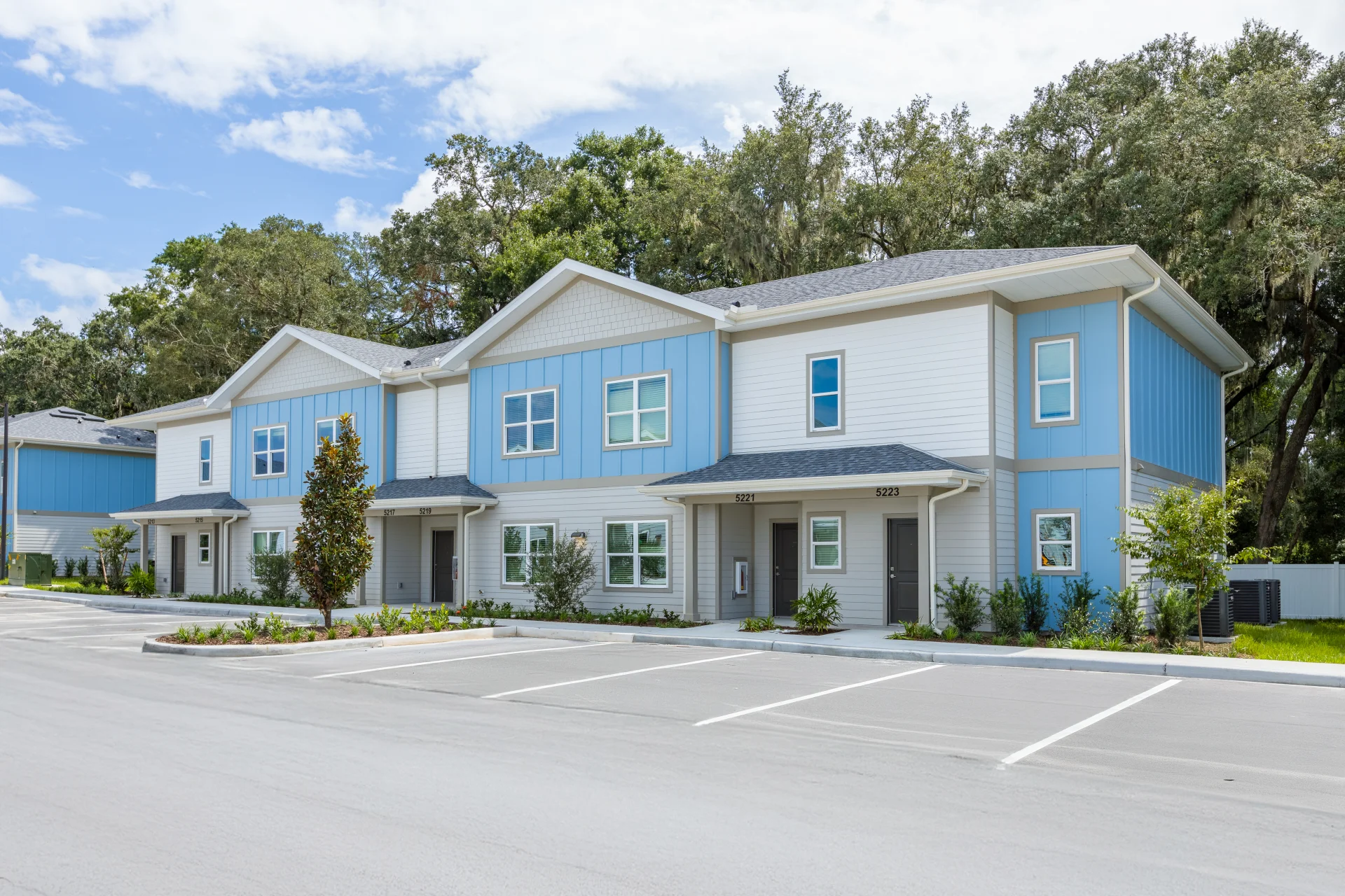 Modern resident clubhouse lounge with a large TV, comfortable seating, and an adjacent billiards table, offering a social space at Magnolia at Powell in Wildwood, Florida.