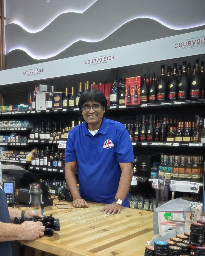 A Liquor Depot team member smiling behind the counter