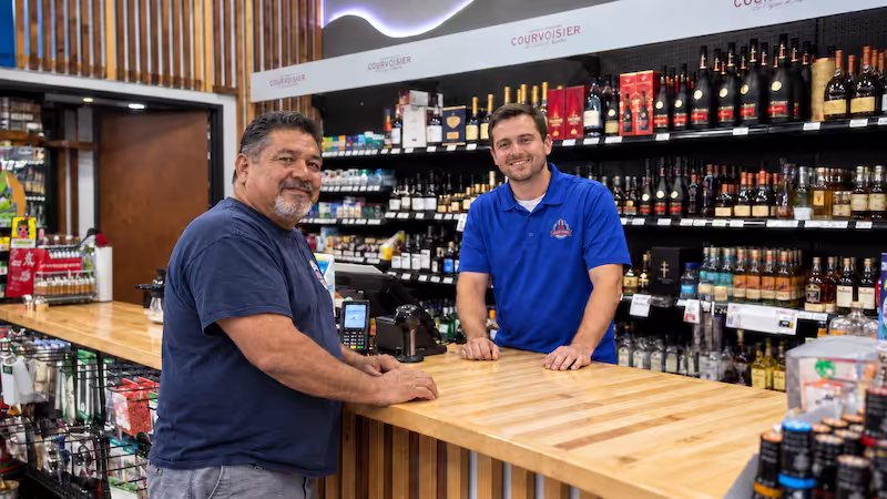 A Liquor Depot team member smiling behind the counter