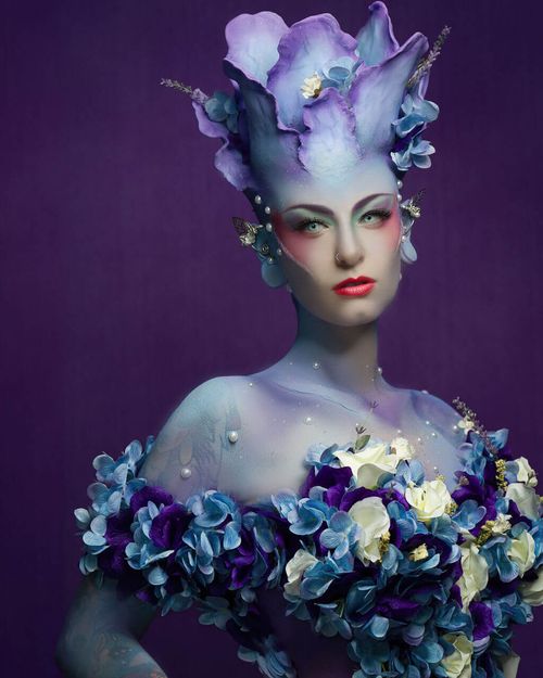 Whitley Queen in blue and purple floral dress, with floral pedal prosthetics on head. Done by OKOS Creations.