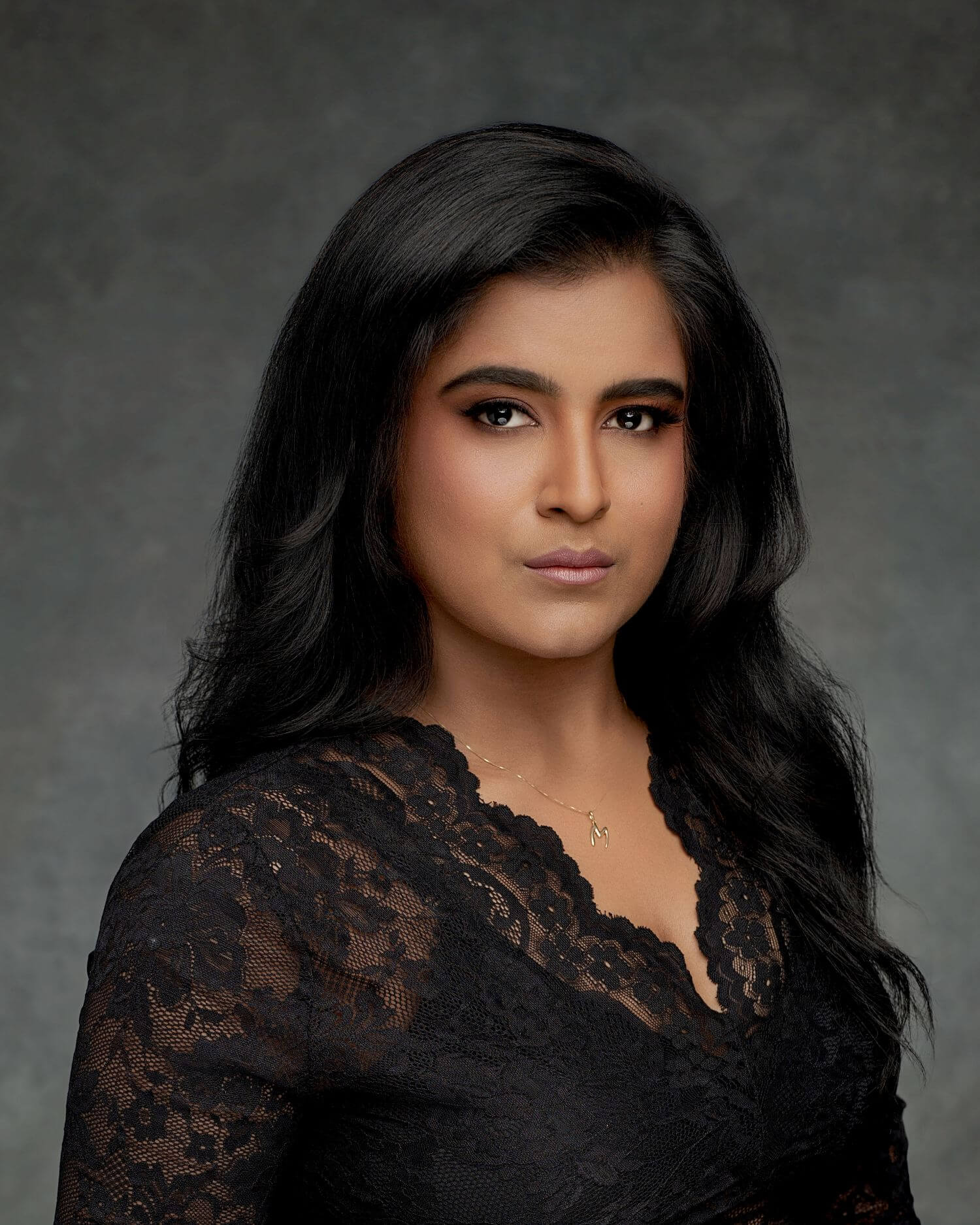 Confident young woman in professional black top and makeup.