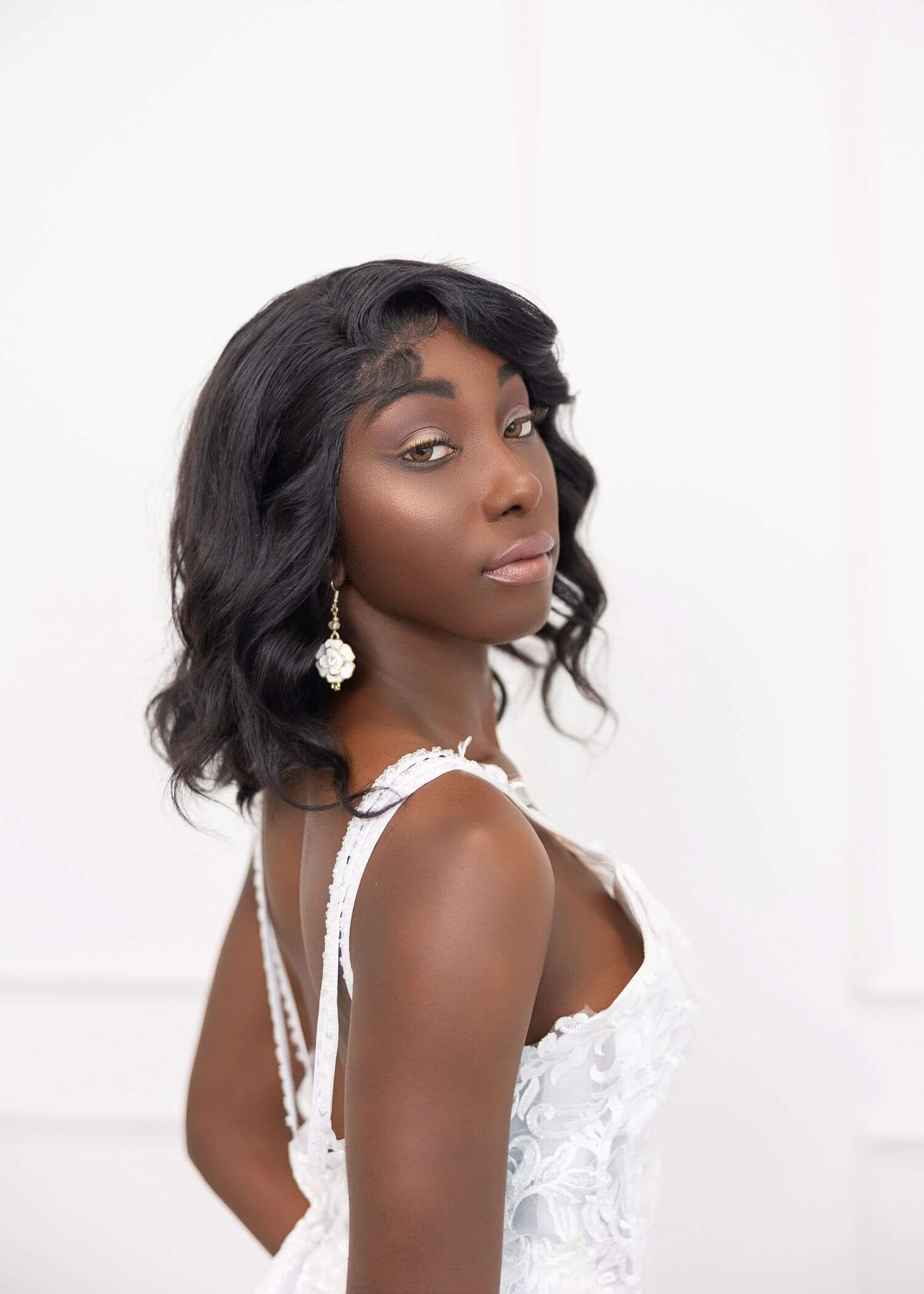 Confident bride looking over shoulder in beautiful makeup by OKOS Creations.