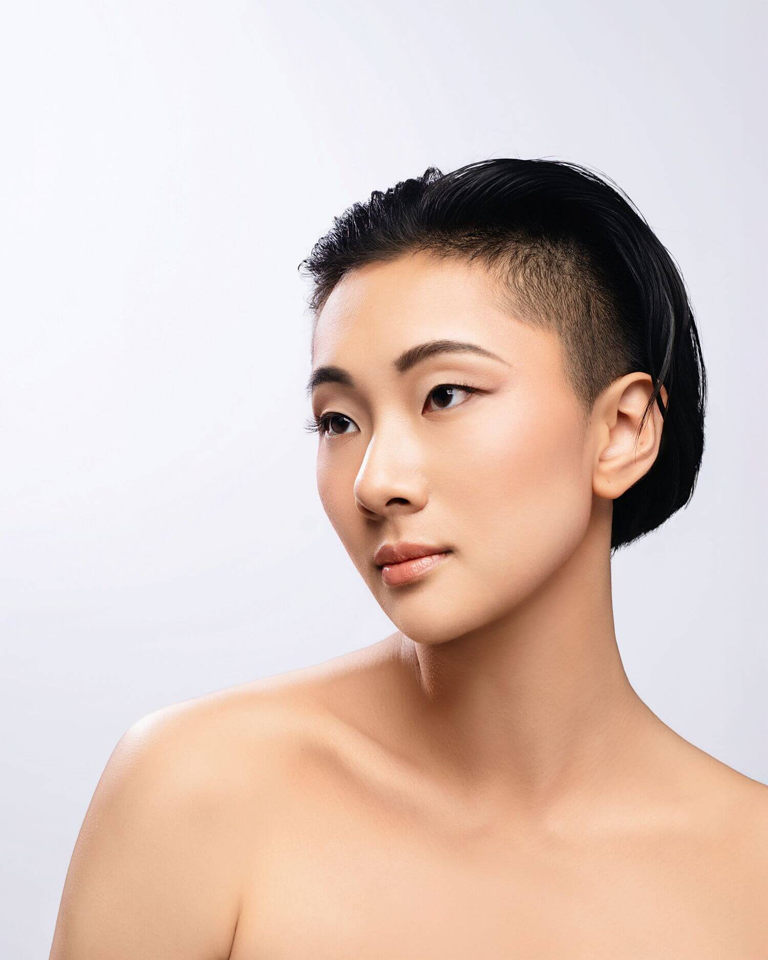 Young Asian woman with flawless beauty makeup in professional headshot.