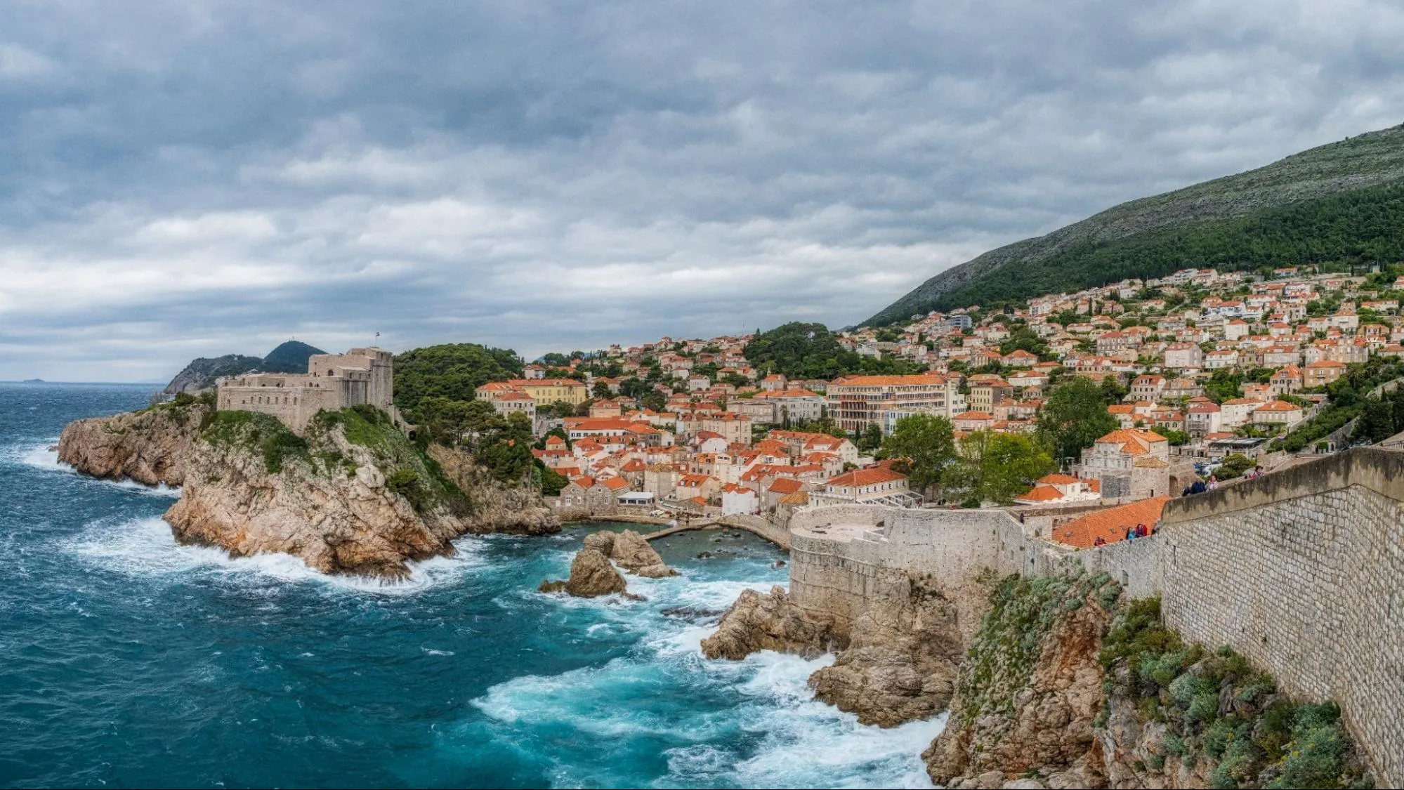 View of a land cliff in Budva, Montenegro showing houses along the coast.