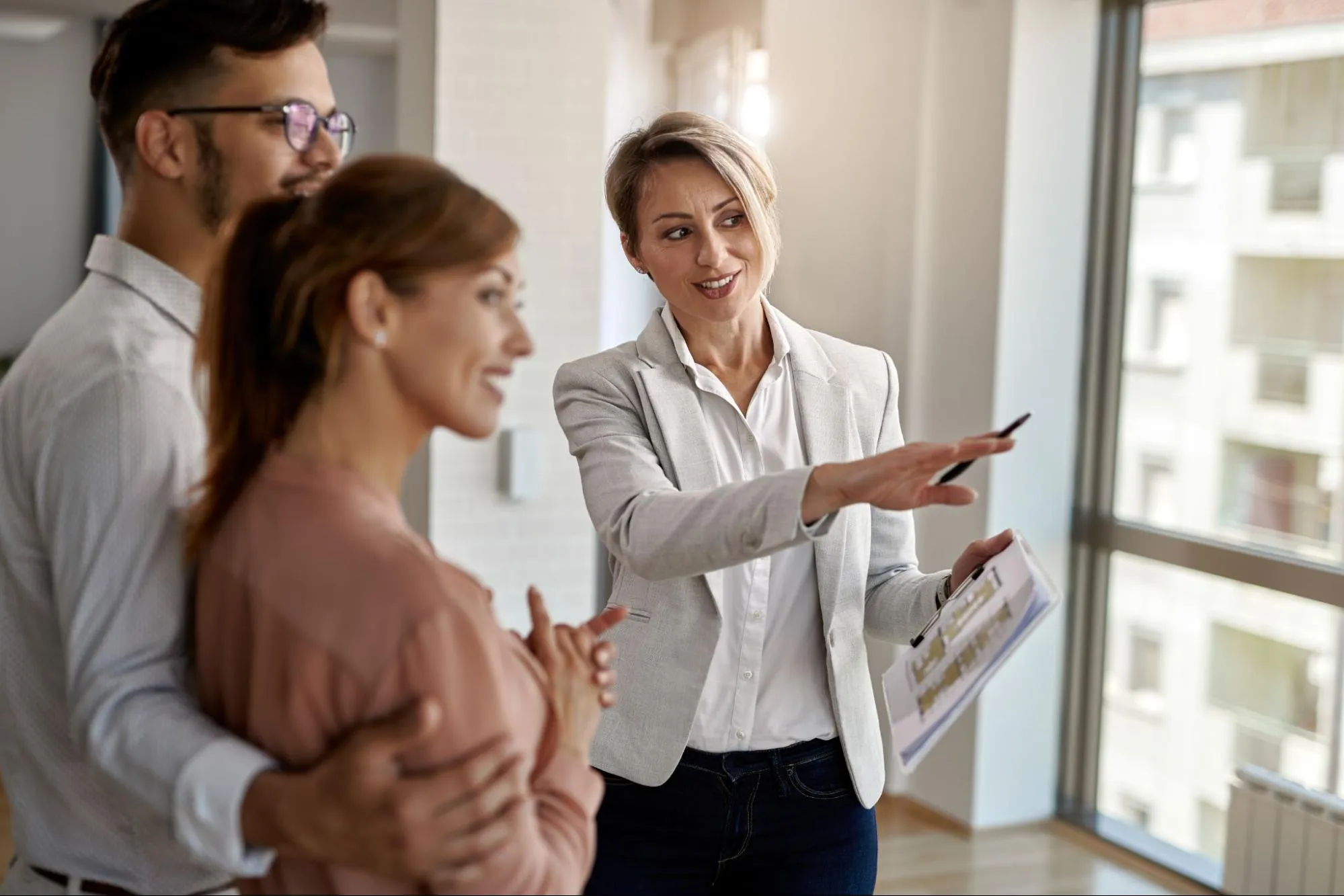 A real estate agent talking with a couple interested in buying a new house.