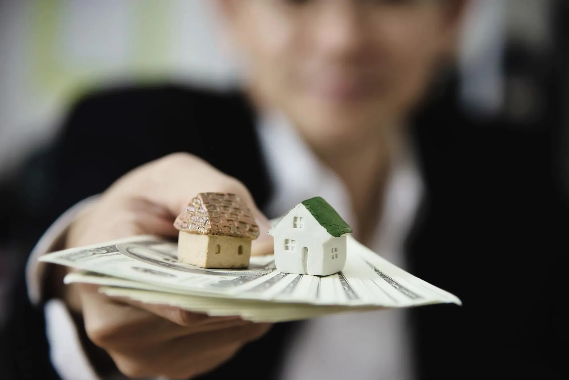 Man showing money notes for real estate funding.