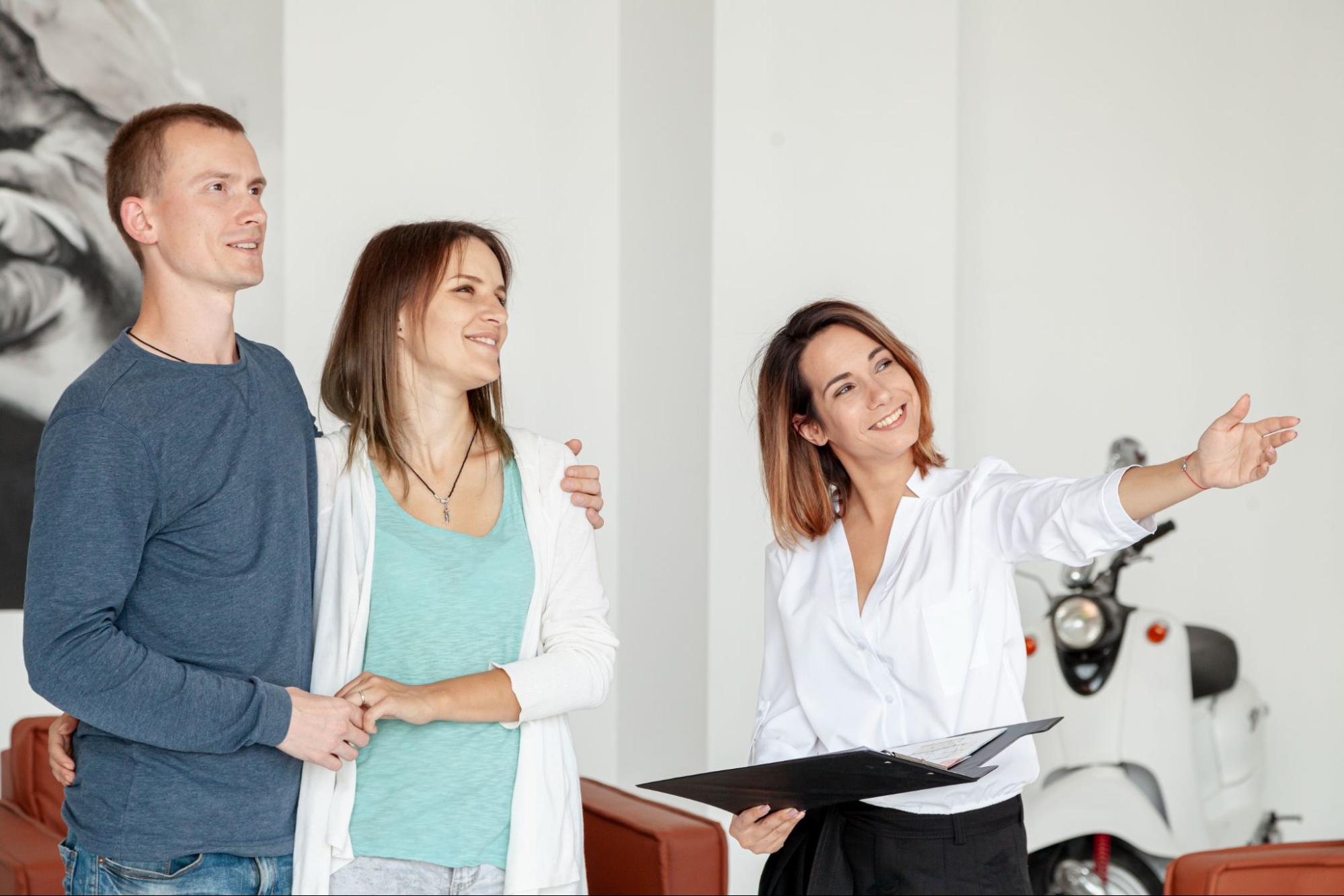 A real estate broker showing property to a couple.