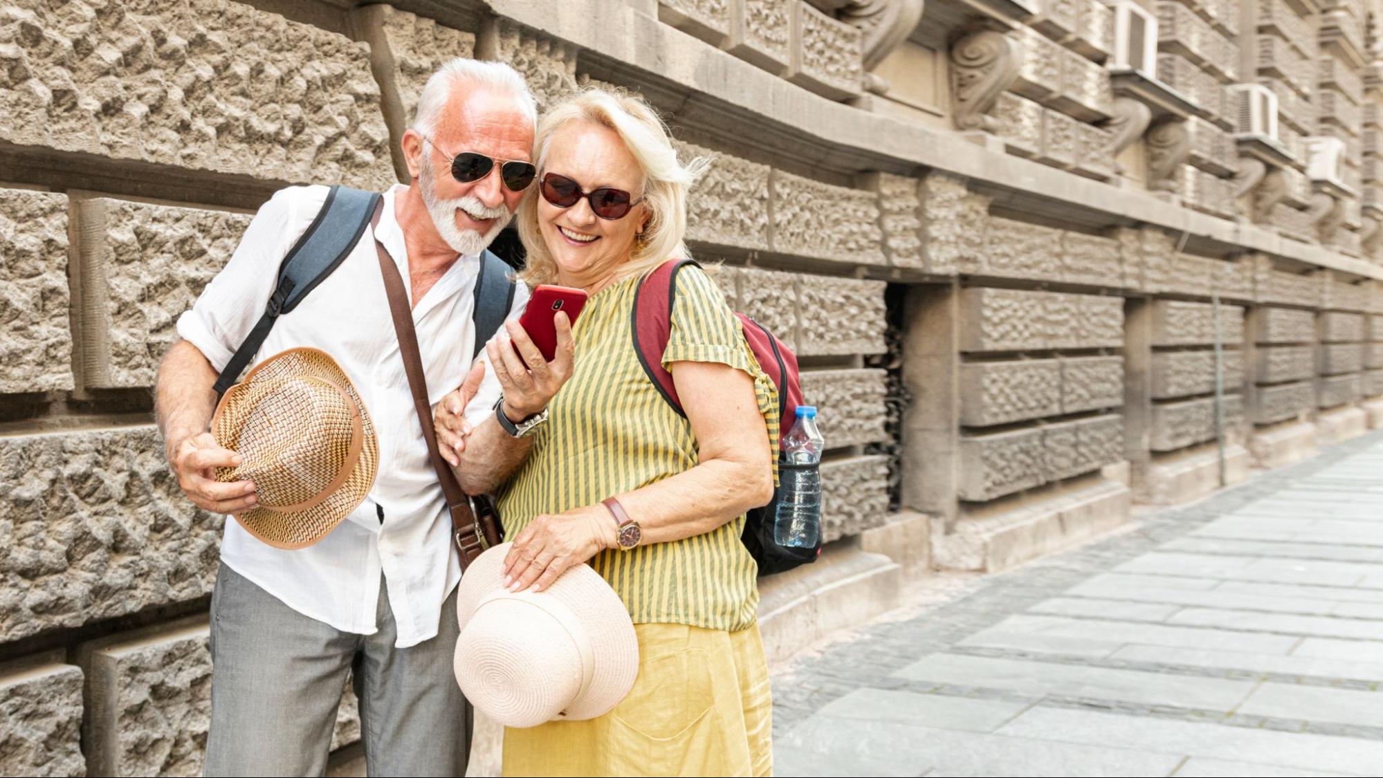 A happy, old couple with a phone.