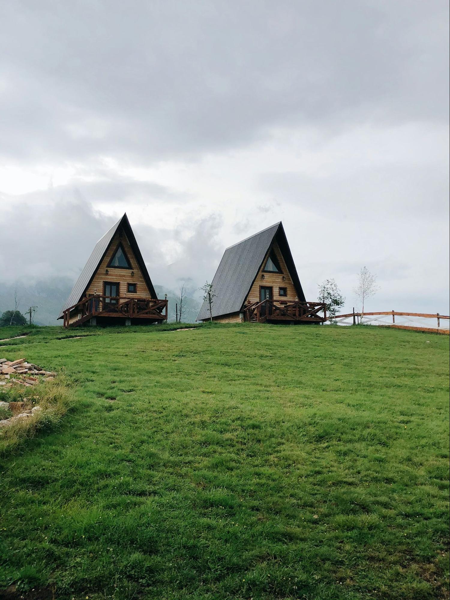Two wooden village houses on a green hill in the north Žabljak, Montenegro.