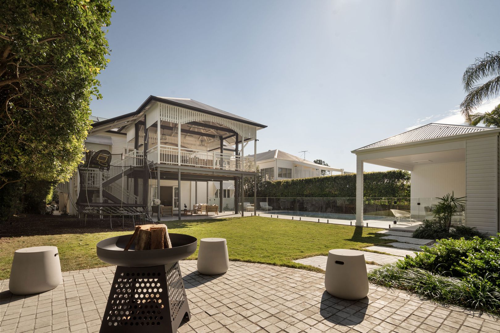 Rear yard looking at paved outdoor area, poorhouse, pool and looking at the rear facade  