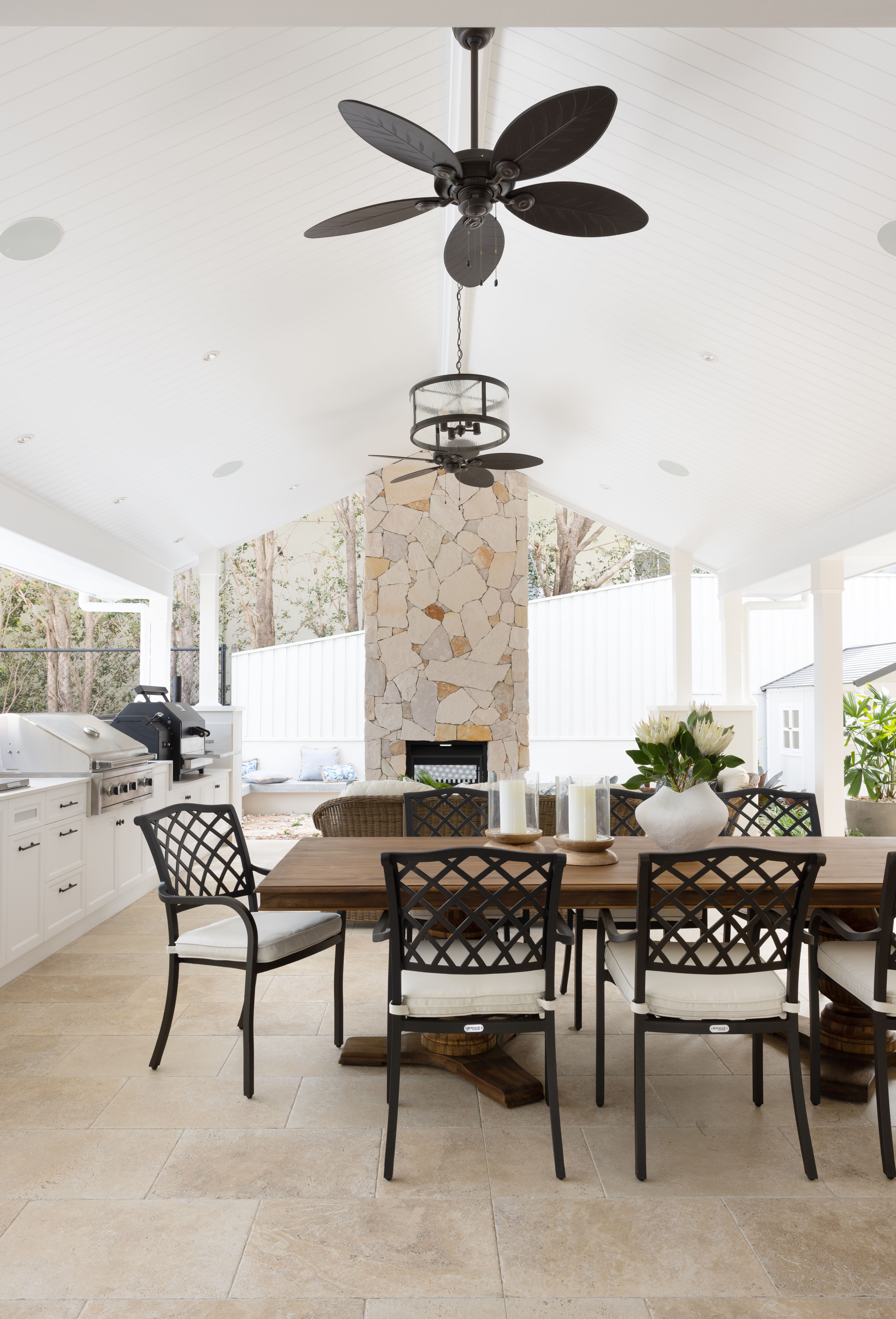 Outdoor living space with alfresco dining and stone double sided fireplace